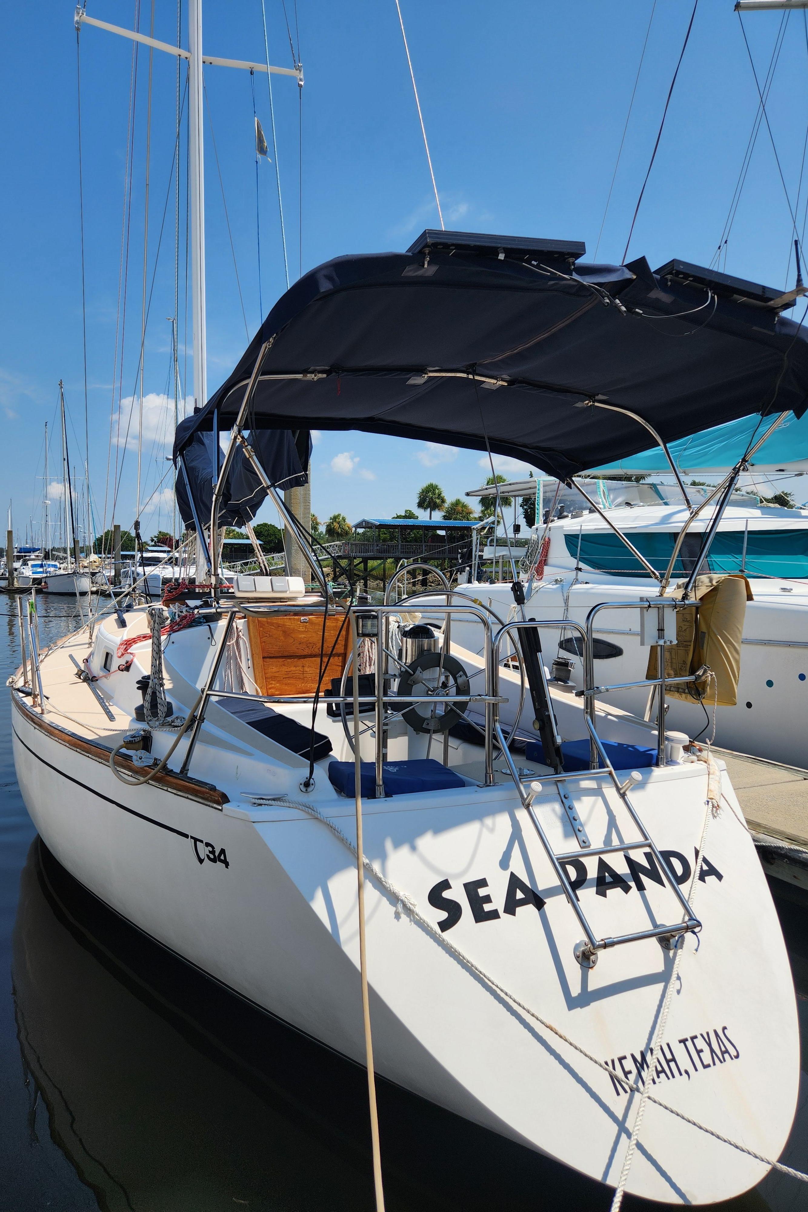 1986 Tartan 34-2 sailboat "Sea Panda" docked in a marina, featuring a blue canopy.