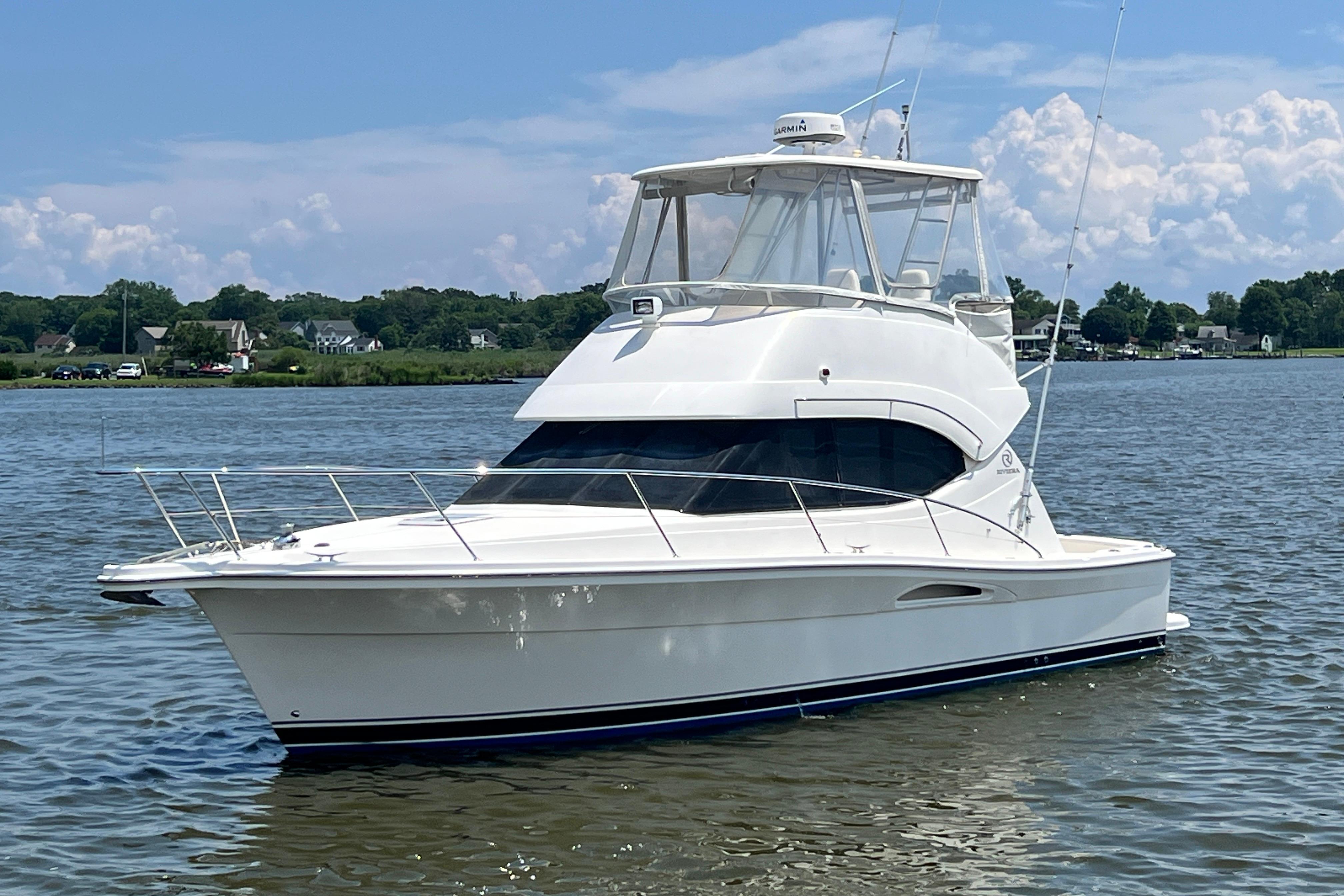 2007 Riviera 33 Flybridge yacht on calm water under a blue sky.