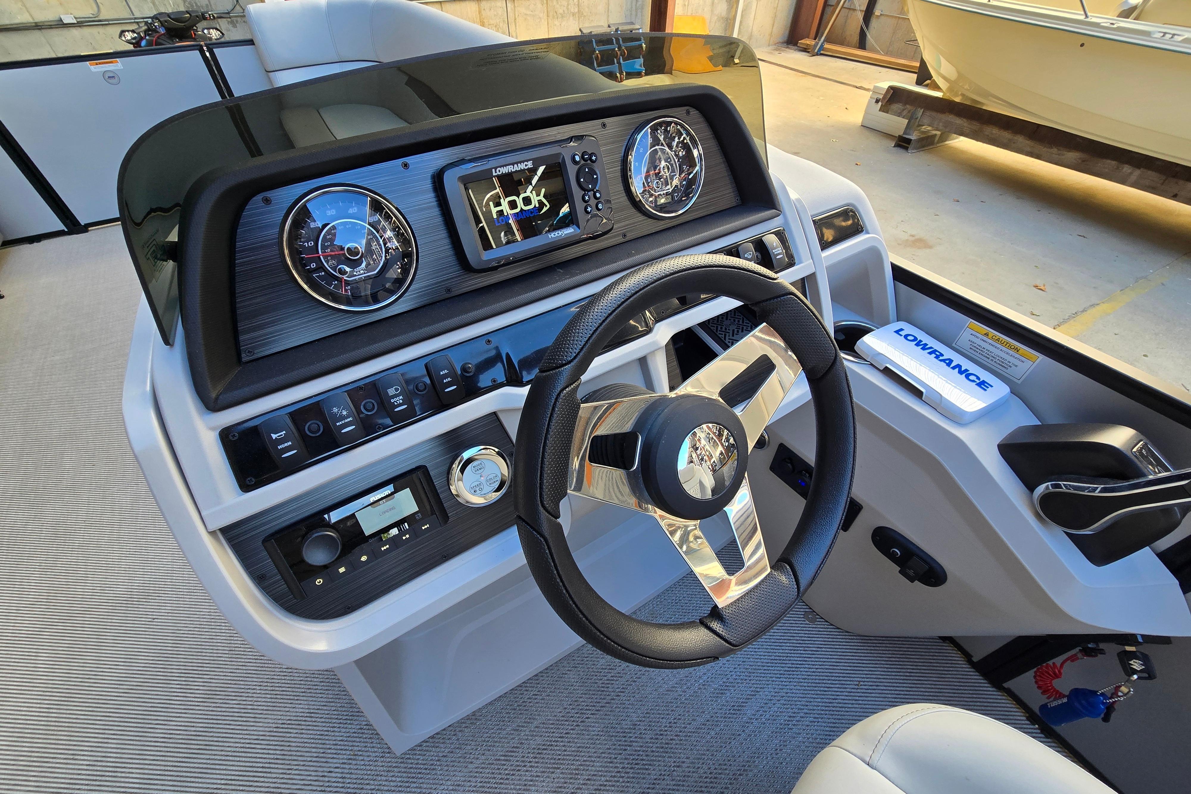 2024 Godfrey Sweetwater 2486 SB boat dashboard with steering wheel and navigation controls.