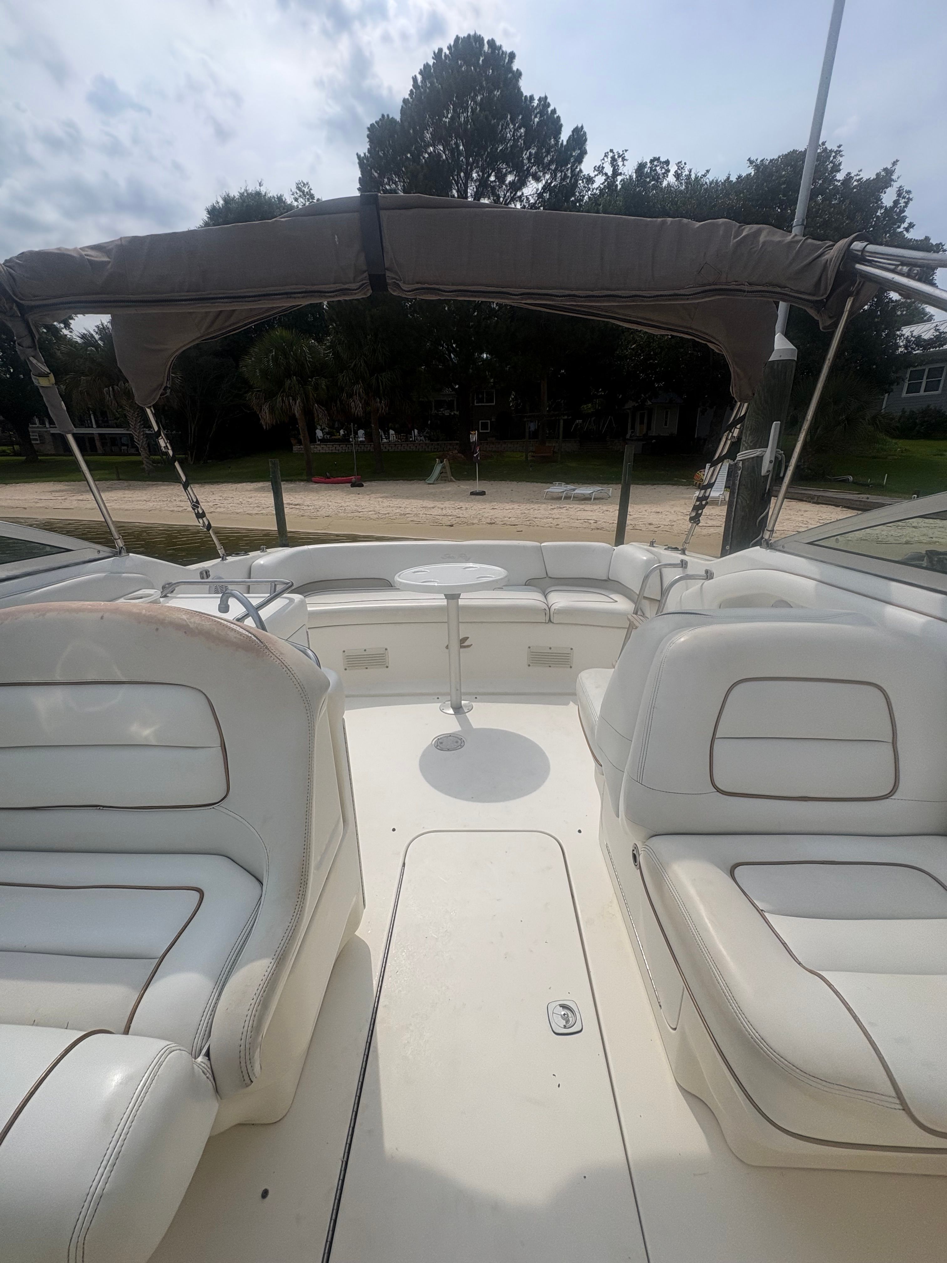 The image shows the cockpit of a Sea Ray 280 Cuddy Cabin boat with white seats and a table.