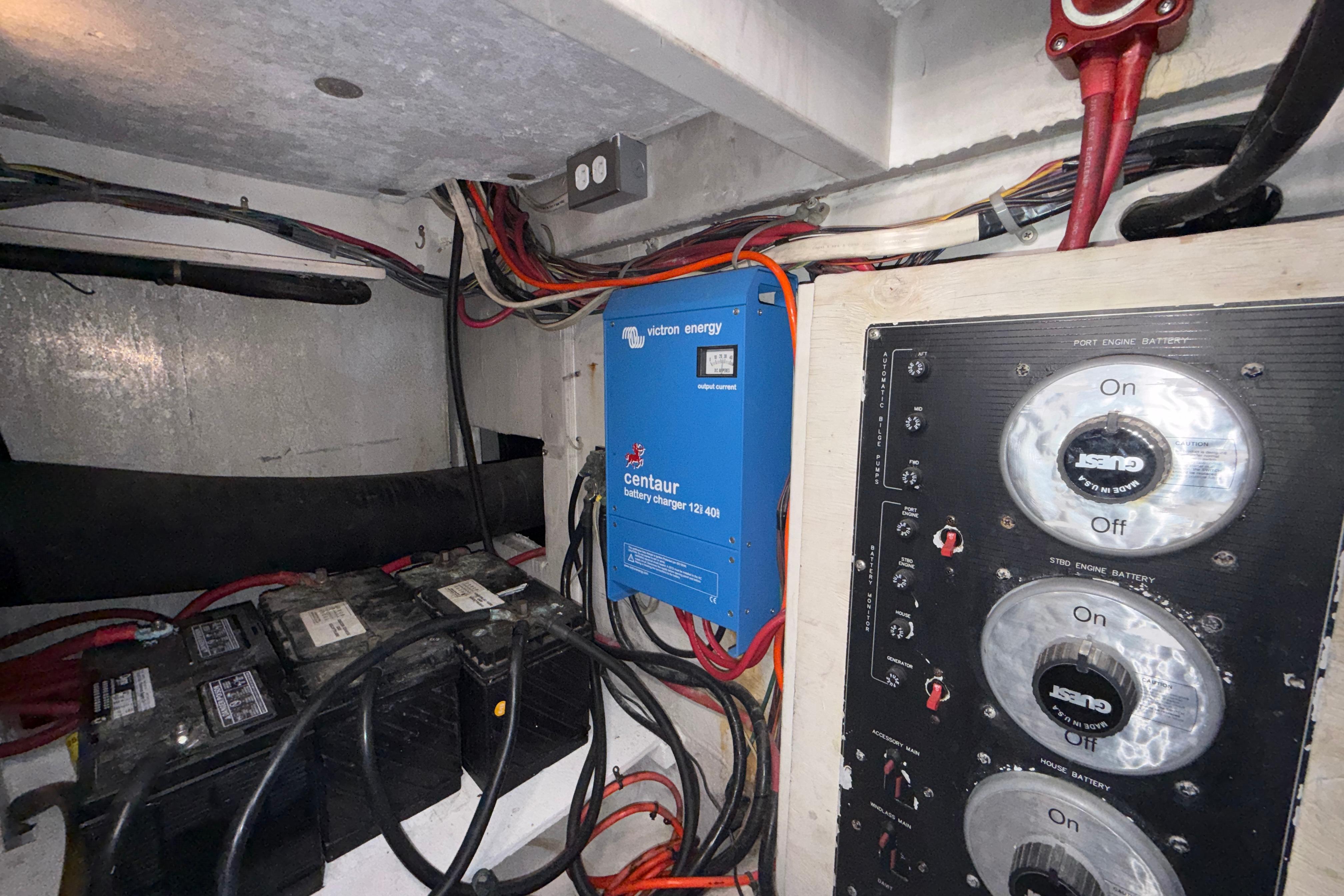 Engine room of 1997 Bayliner 3988 Command Bridge Motoryacht with battery charger and control panel.
