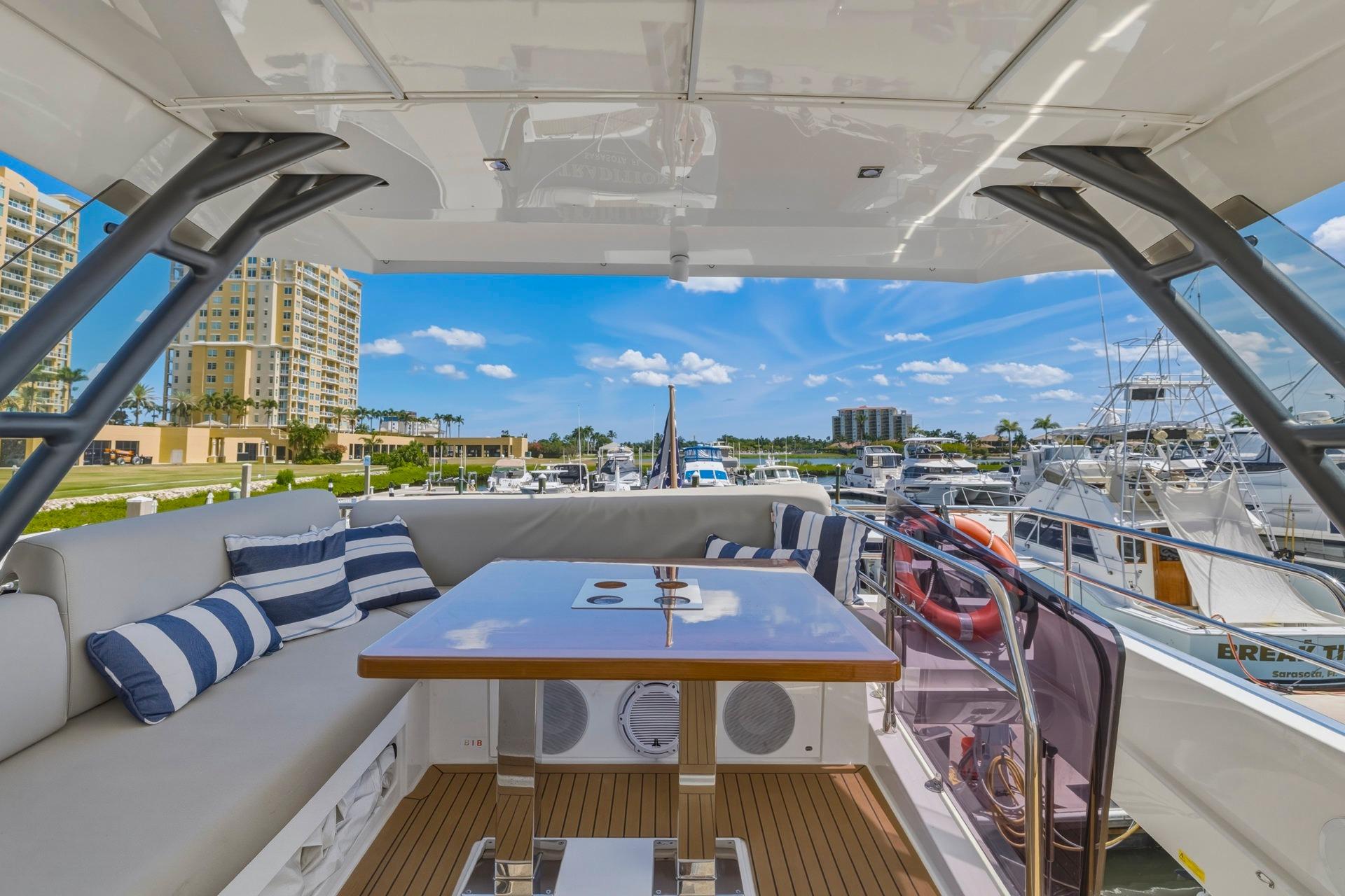 Luxurious 2022 Prestige 520 yacht interior with striped cushions, docked at a marina.