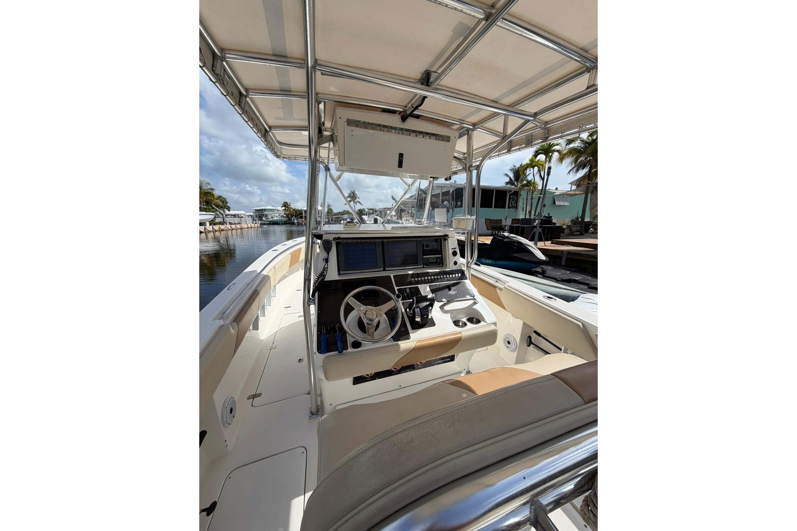 2007 Fountain 34 Center Console boat interior with steering wheel and navigation equipment.