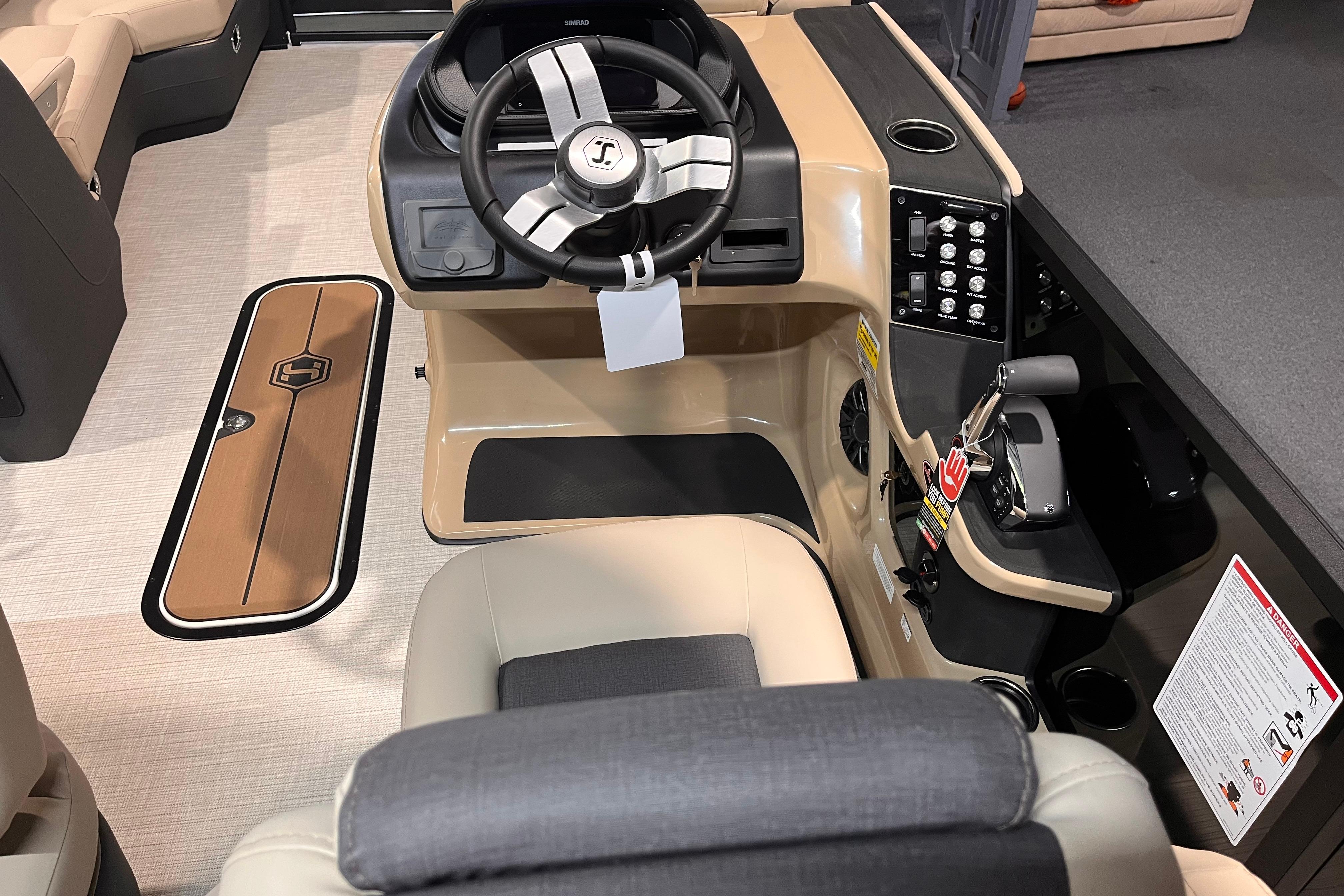 Interior view of 2026 Harris Sunliner 250 boat cockpit with steering wheel and controls.