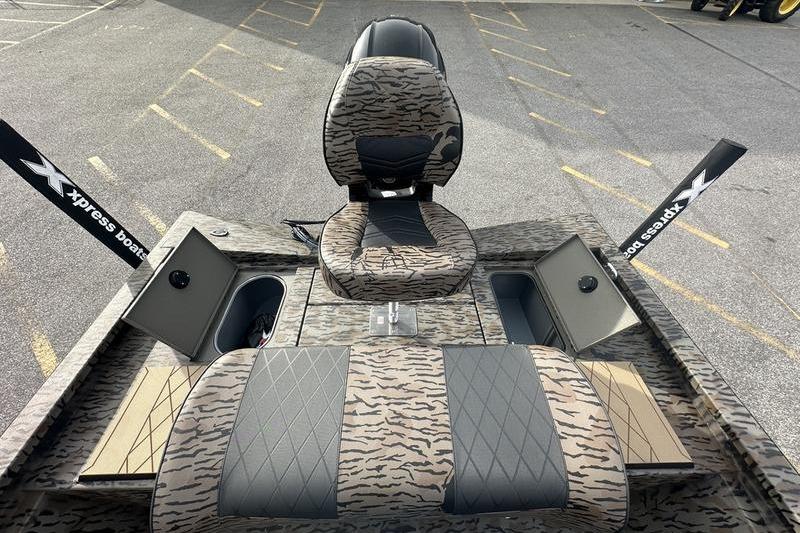 2026 Xpress H190B Bay boat interior with camo seats and storage compartments.
