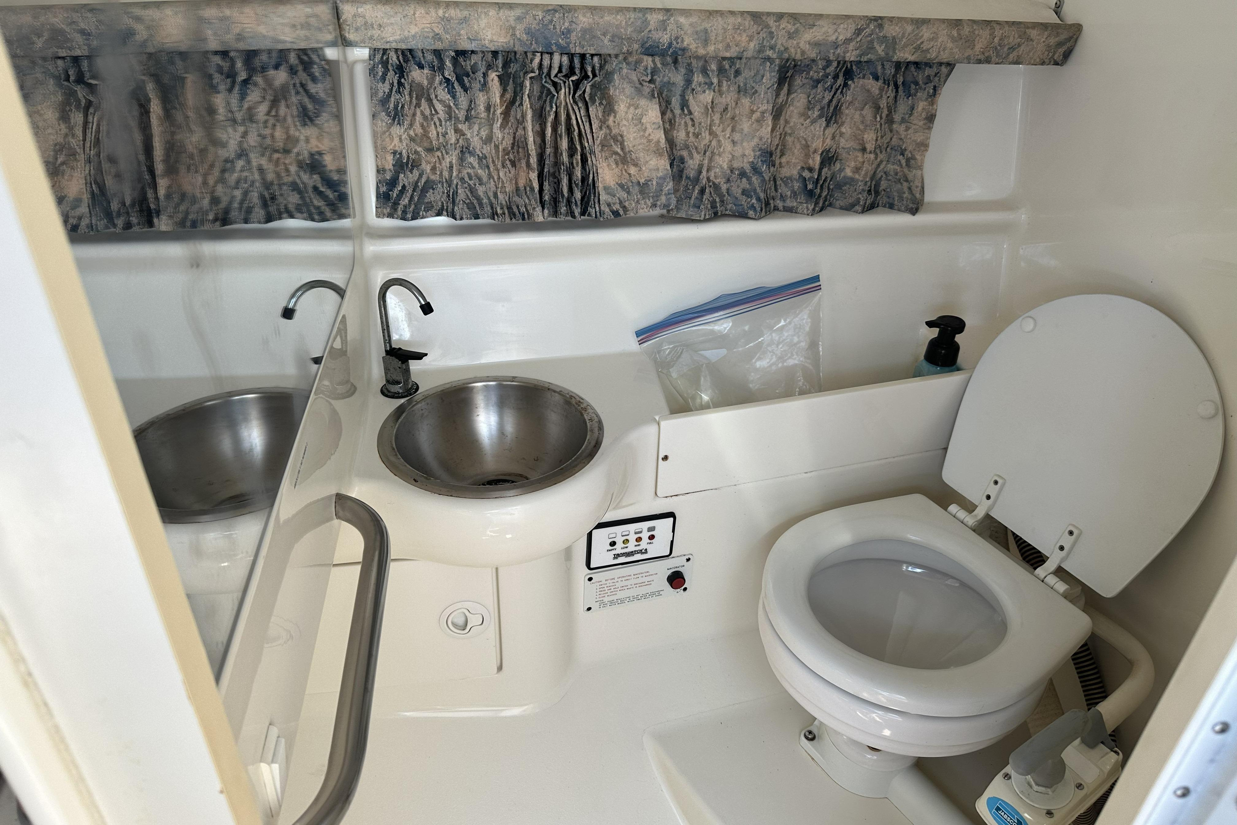 Compact bathroom in a 2000 Formula 280 Sun Sport boat, featuring a sink and toilet.
