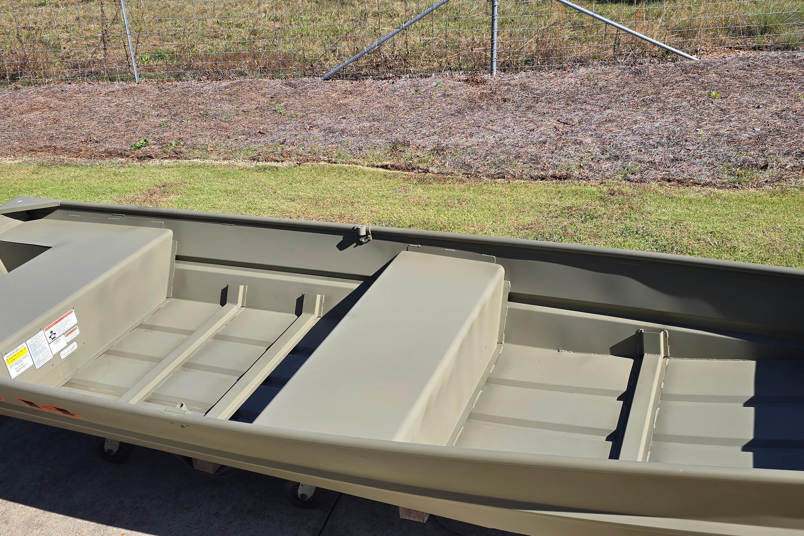 2026 Tracker Grizzly 14 Jon boat on grass, showcasing interior seating and storage.