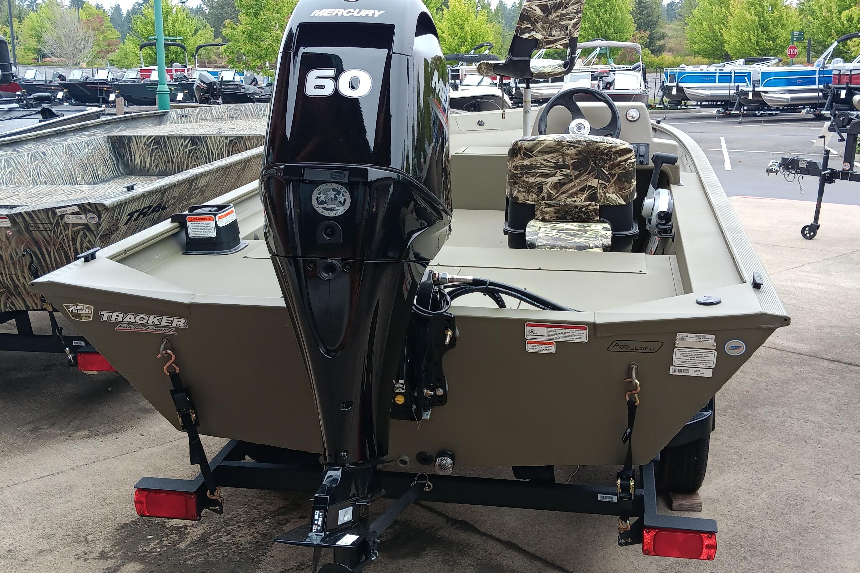 2026 Tracker Grizzly 1754 SC boat with Mercury 60 engine, camo seats, parked outdoors.