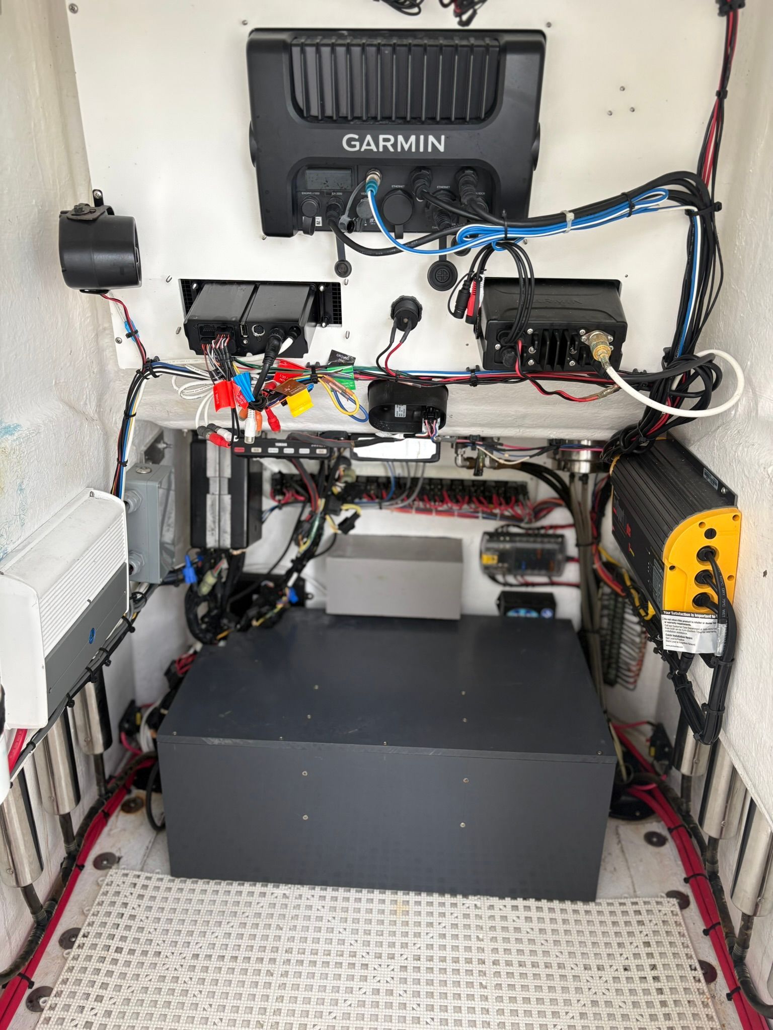 Electronics and wiring systems inside a boat, with Garmin device on the wall.
