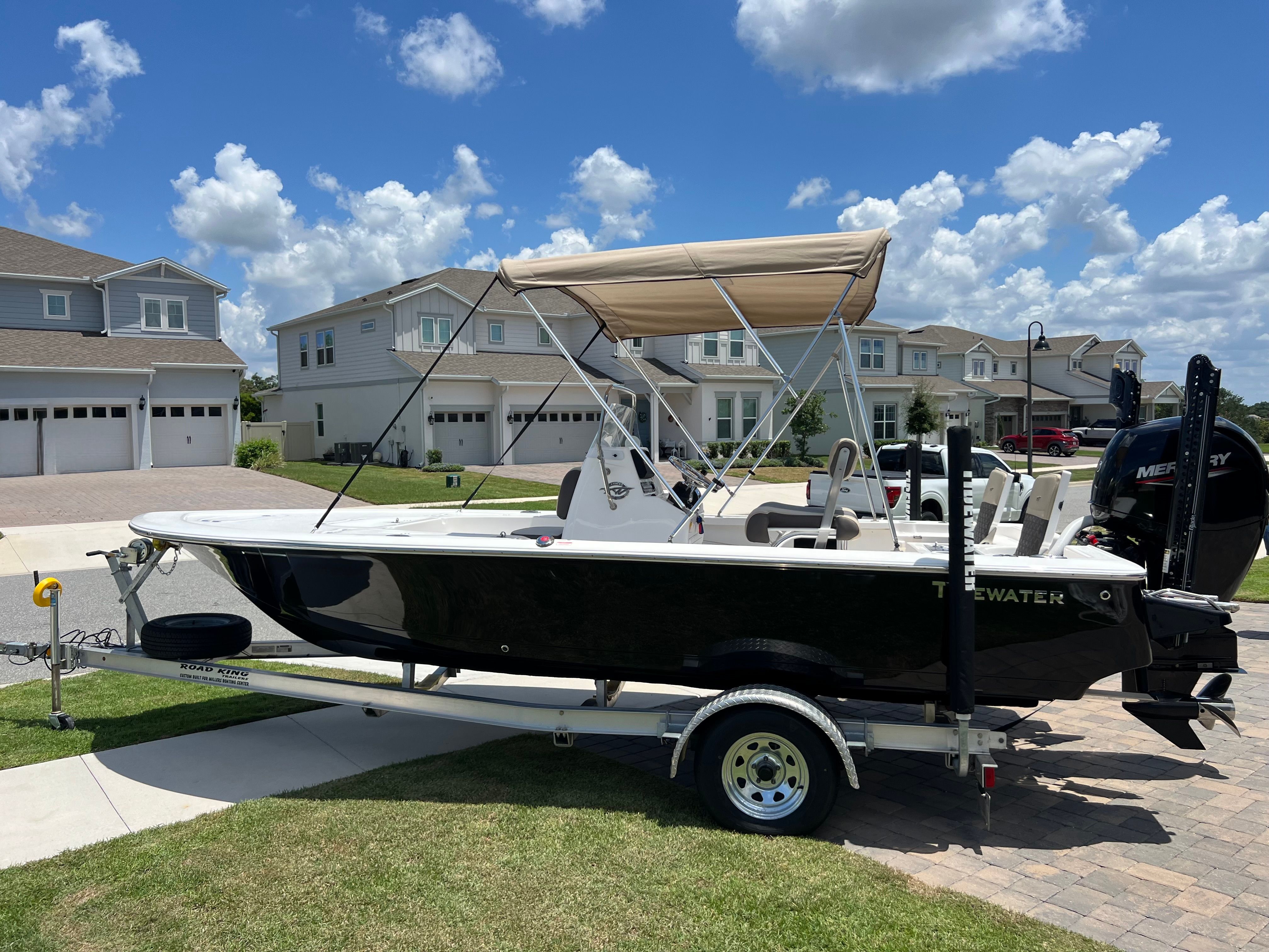 A 2021 Tidewater 1910 Bay Max boat on a trailer in a residential area.
