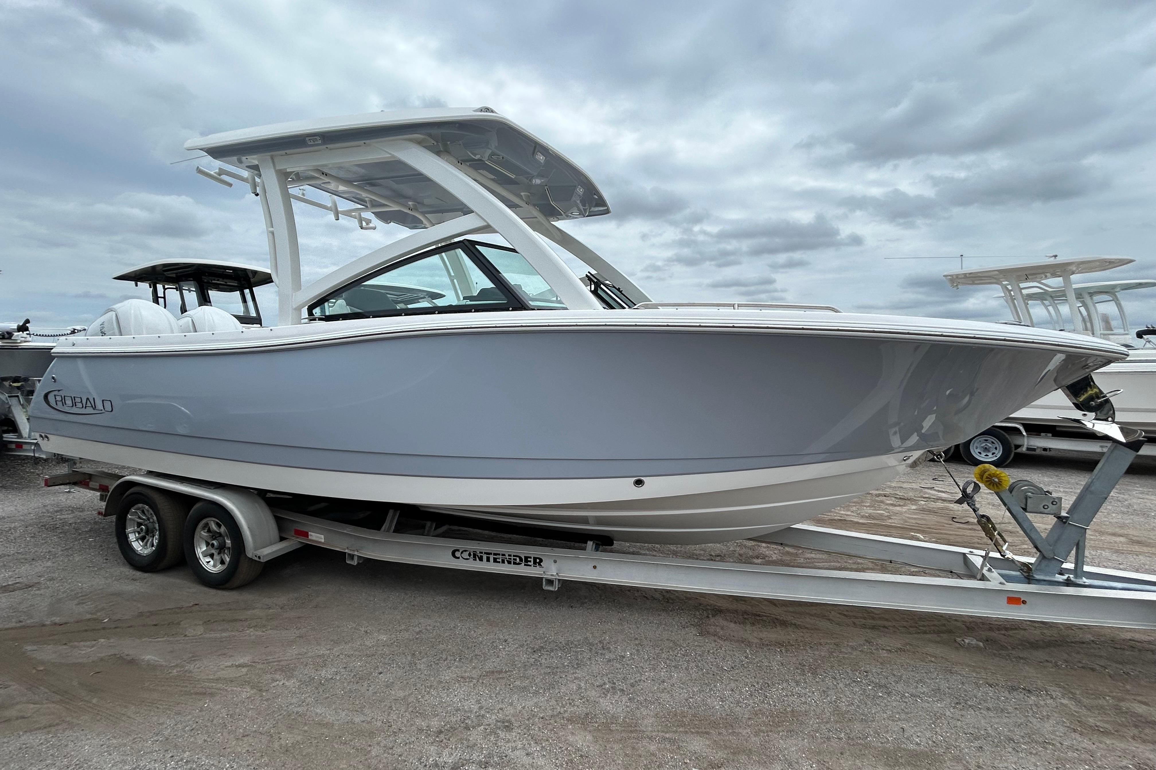 2026 Robalo R277 Dual Console boat on trailer under cloudy sky.