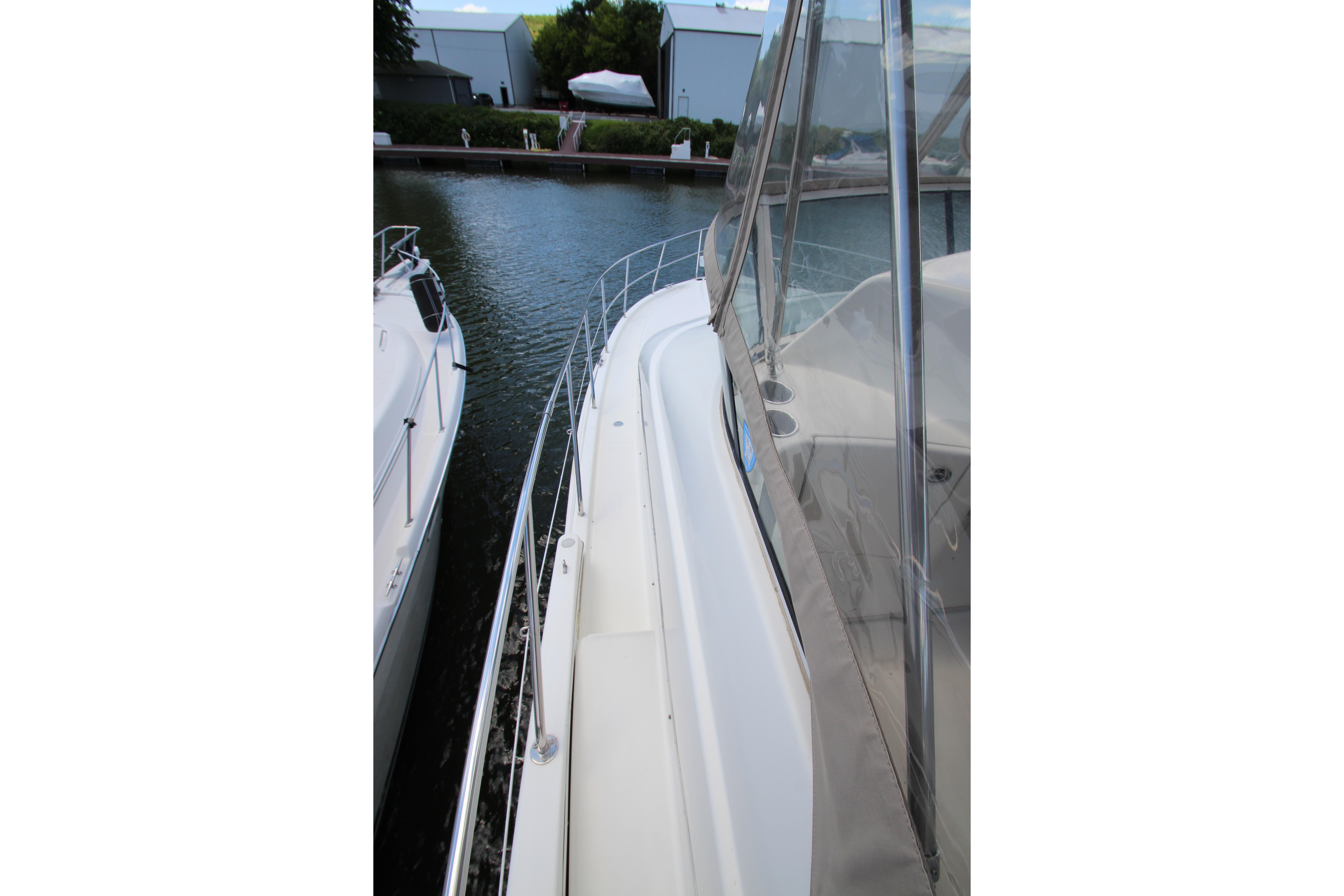 2006 Silverton 38 Sport Bridge yacht docked, showcasing sleek design and spacious deck area.