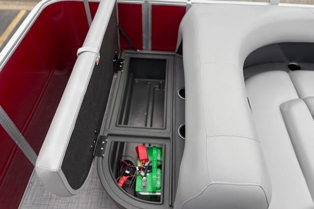 2026 Sun Tracker Party Barge 18 DLX storage compartment with battery and seating.