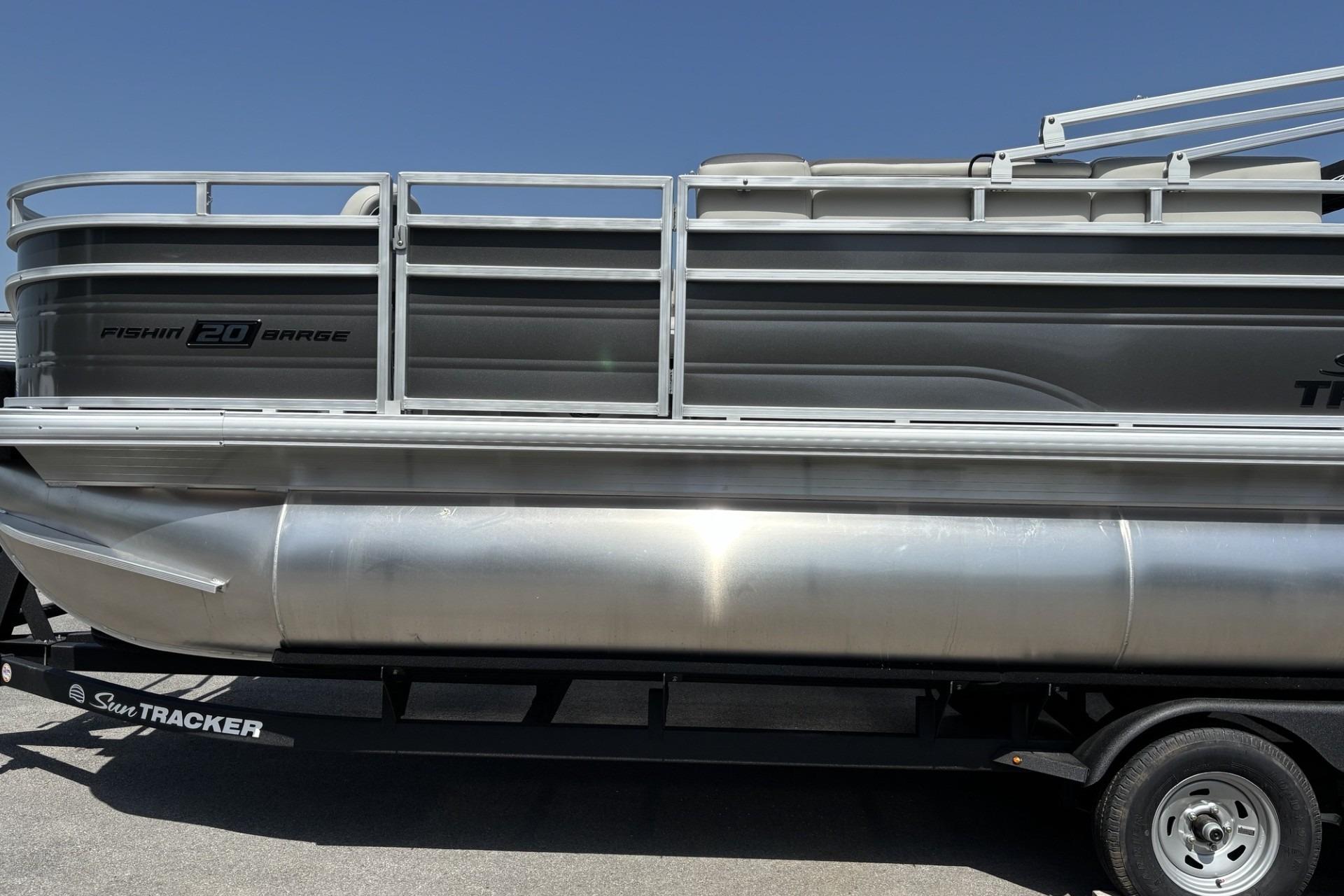 2026 Sun Tracker Fishin' Barge 20 DLX pontoon boat on trailer, side view.