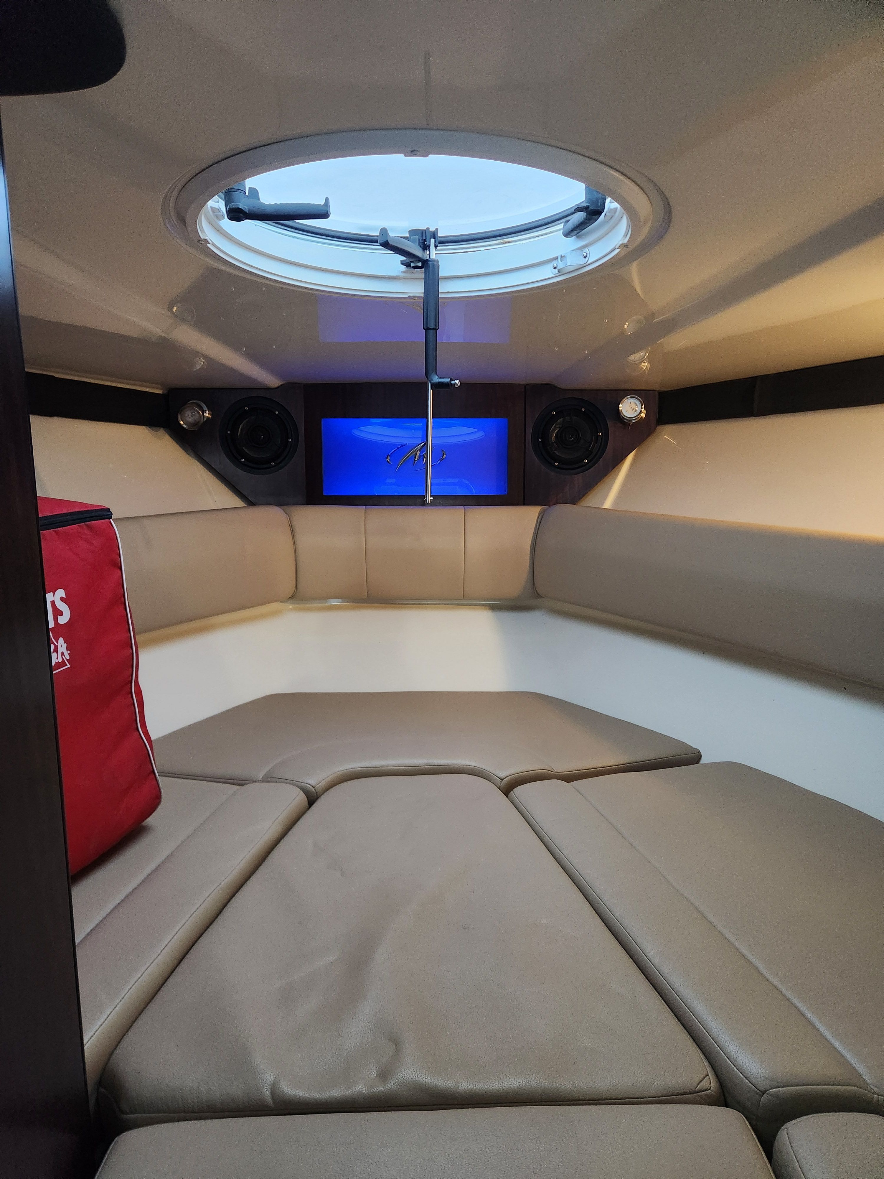 Interior of a 2015 Monterey 268SSC boat with cushions and porthole.