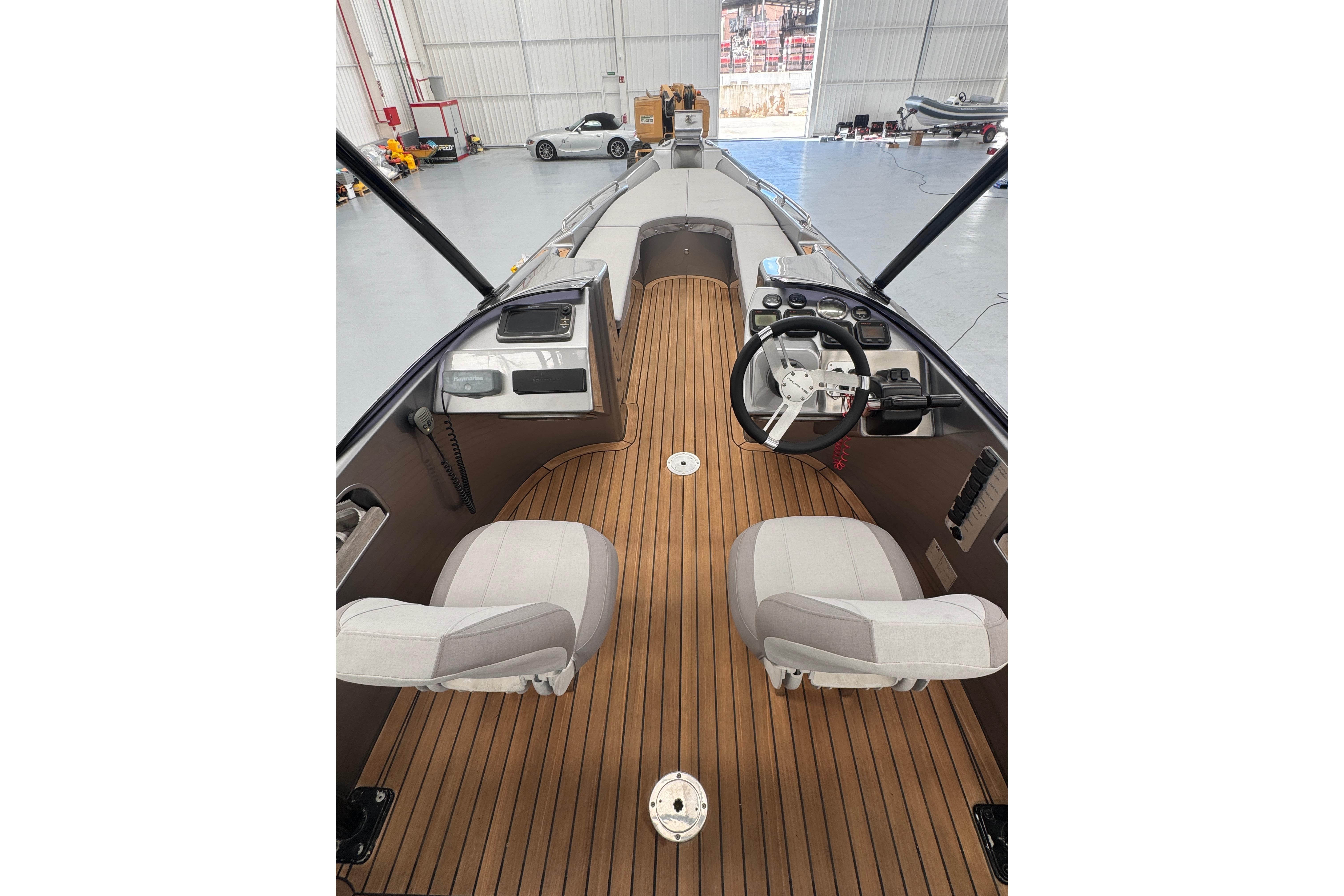 2011 Naumatec Freccia 800 boat interior with wooden deck and steering console.