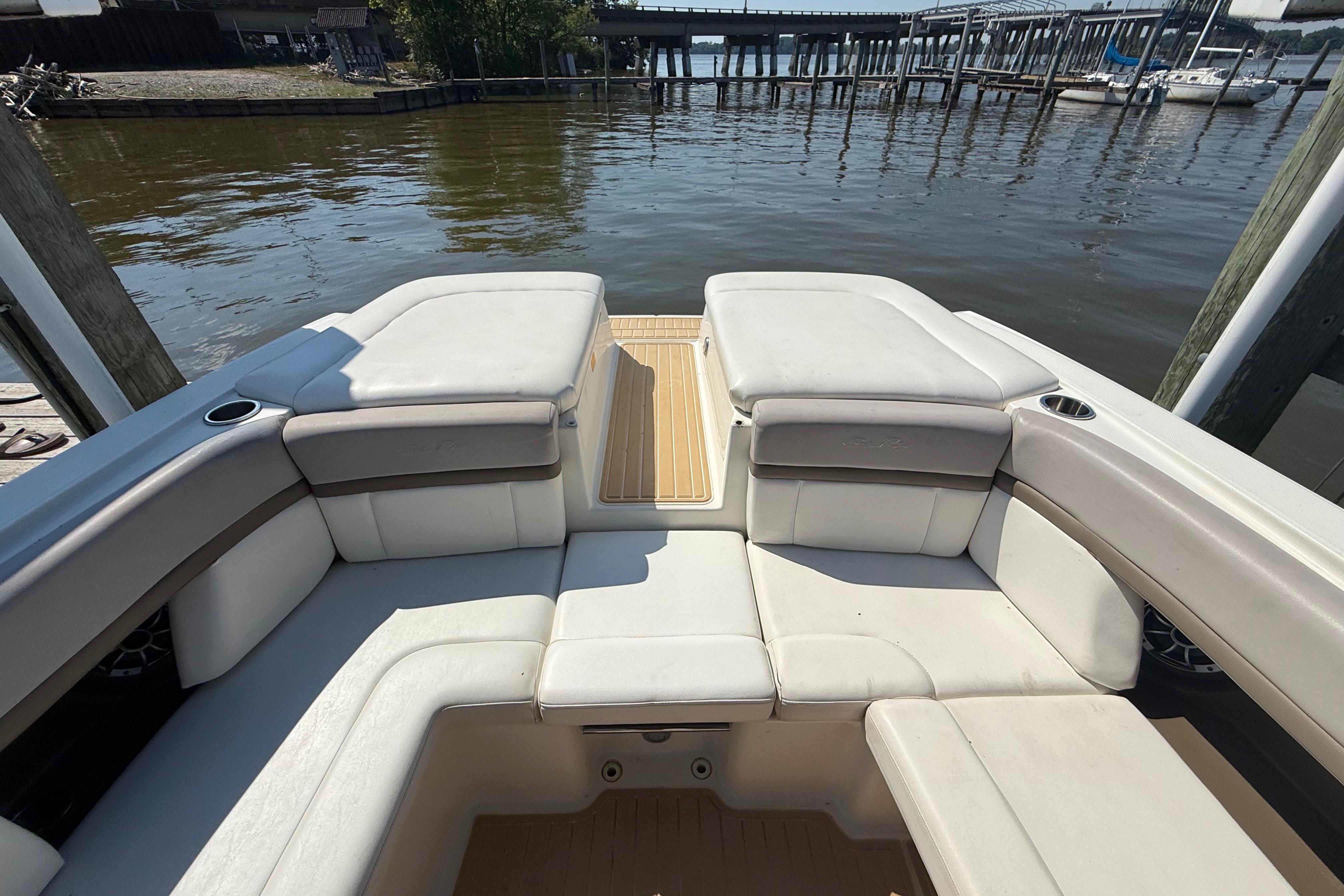 2011 Sea Ray 270 SLX boat interior with white seating, docked by the water.