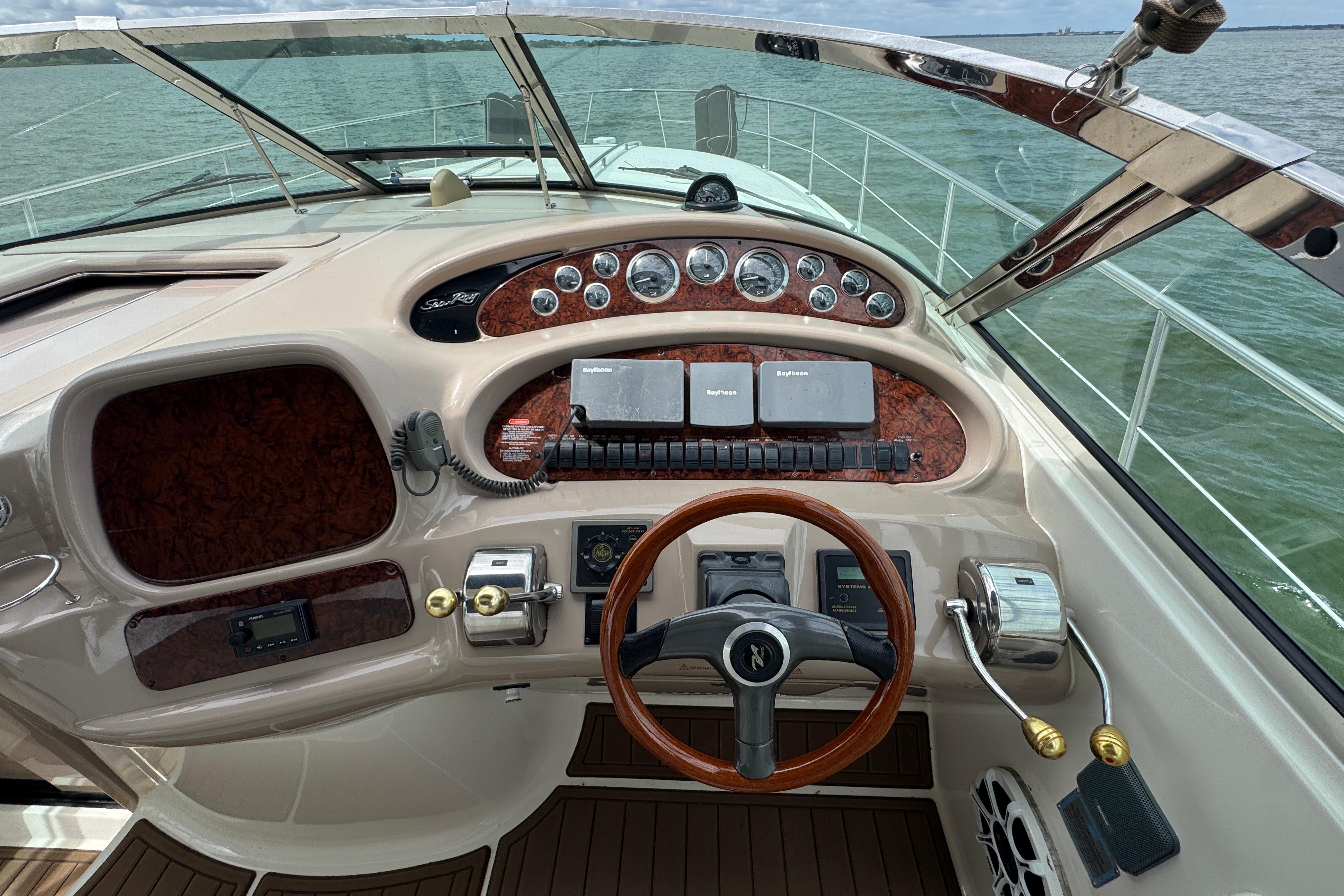 Cockpit view of a 2001 Sea Ray 380 Sundancer yacht with steering wheel and navigation instruments.
