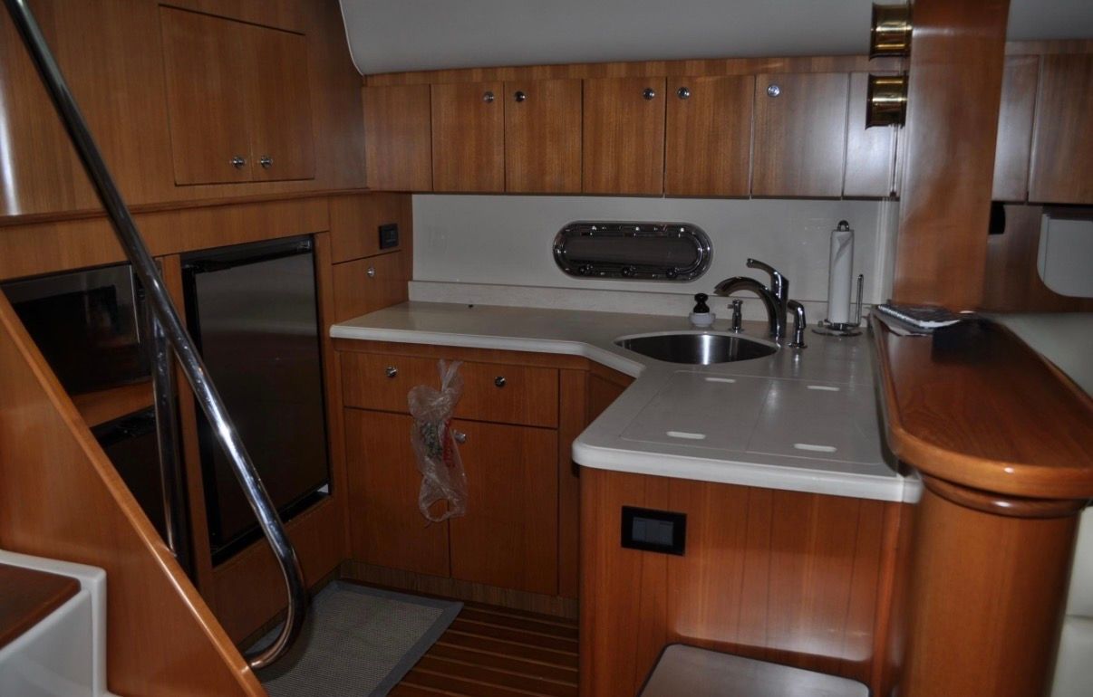 Interior of the 2005 Tiara Yachts 5200 Sovran with elegant wood finish and modern kitchen.