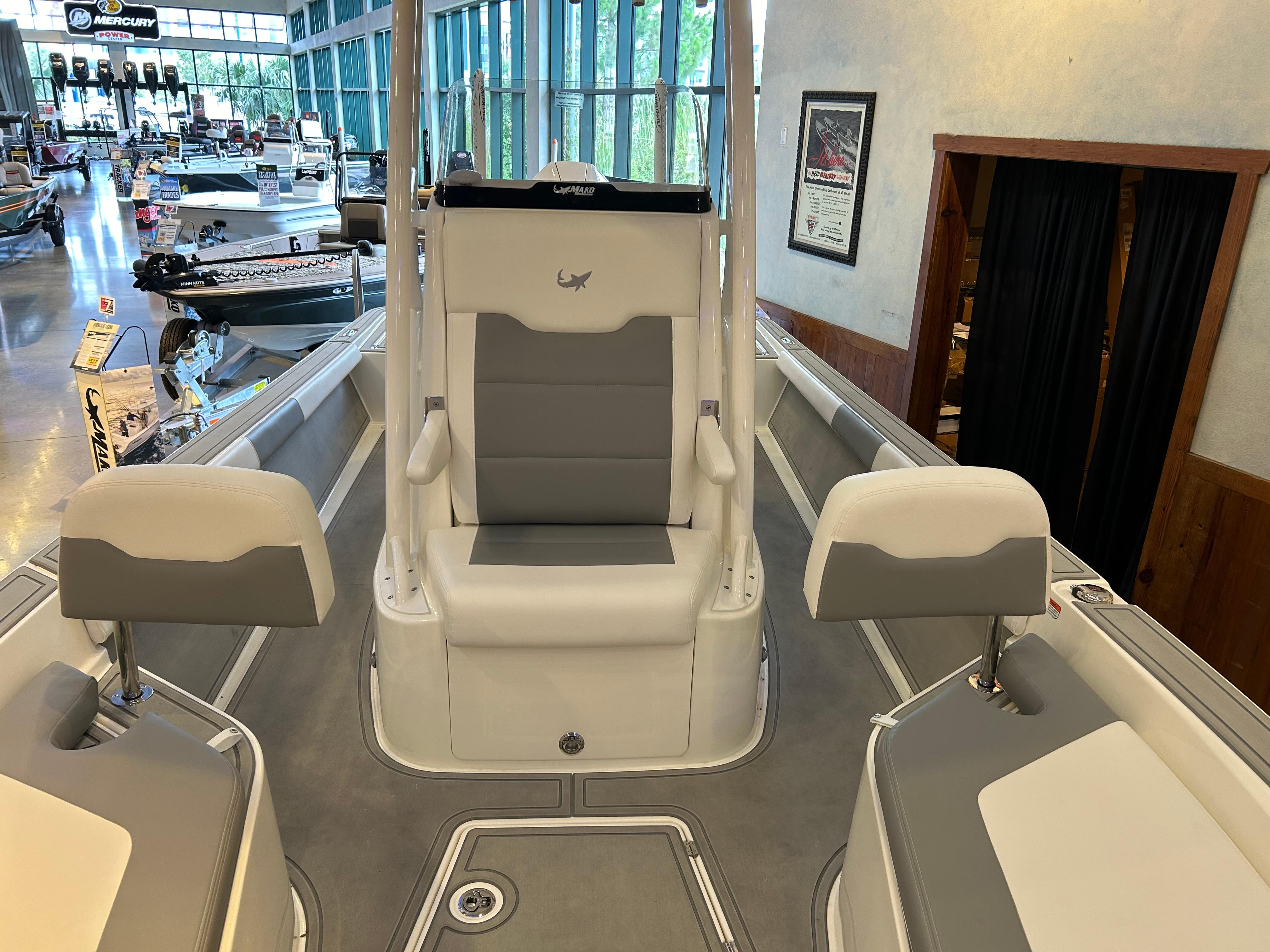 2025 Mako 24 APEX boat interior with seating, displayed in a showroom.