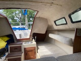 Interior of a 1986 Wellcraft Starwind 19 with seating area and small sink.