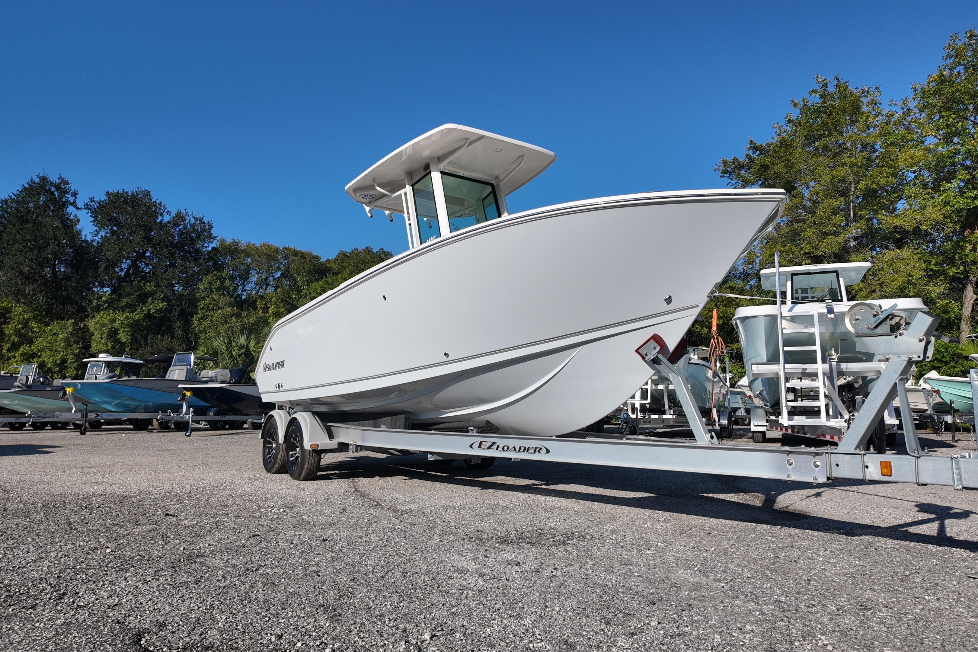 2026 Sailfish 232 CC boat on trailer, parked outdoors under clear blue sky.