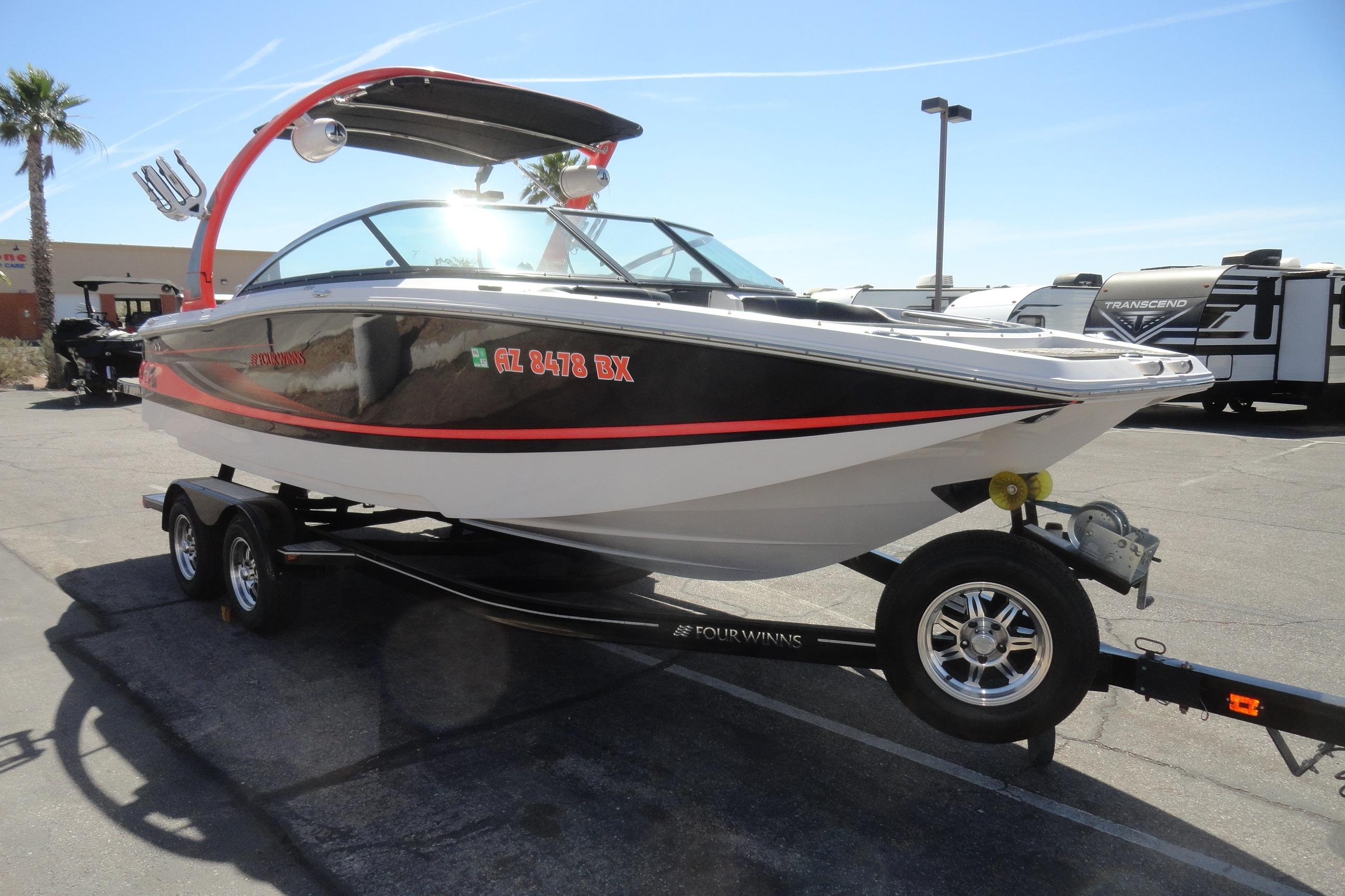 2016 Four Winns TS222 boat on trailer, parked outdoors under clear sky.