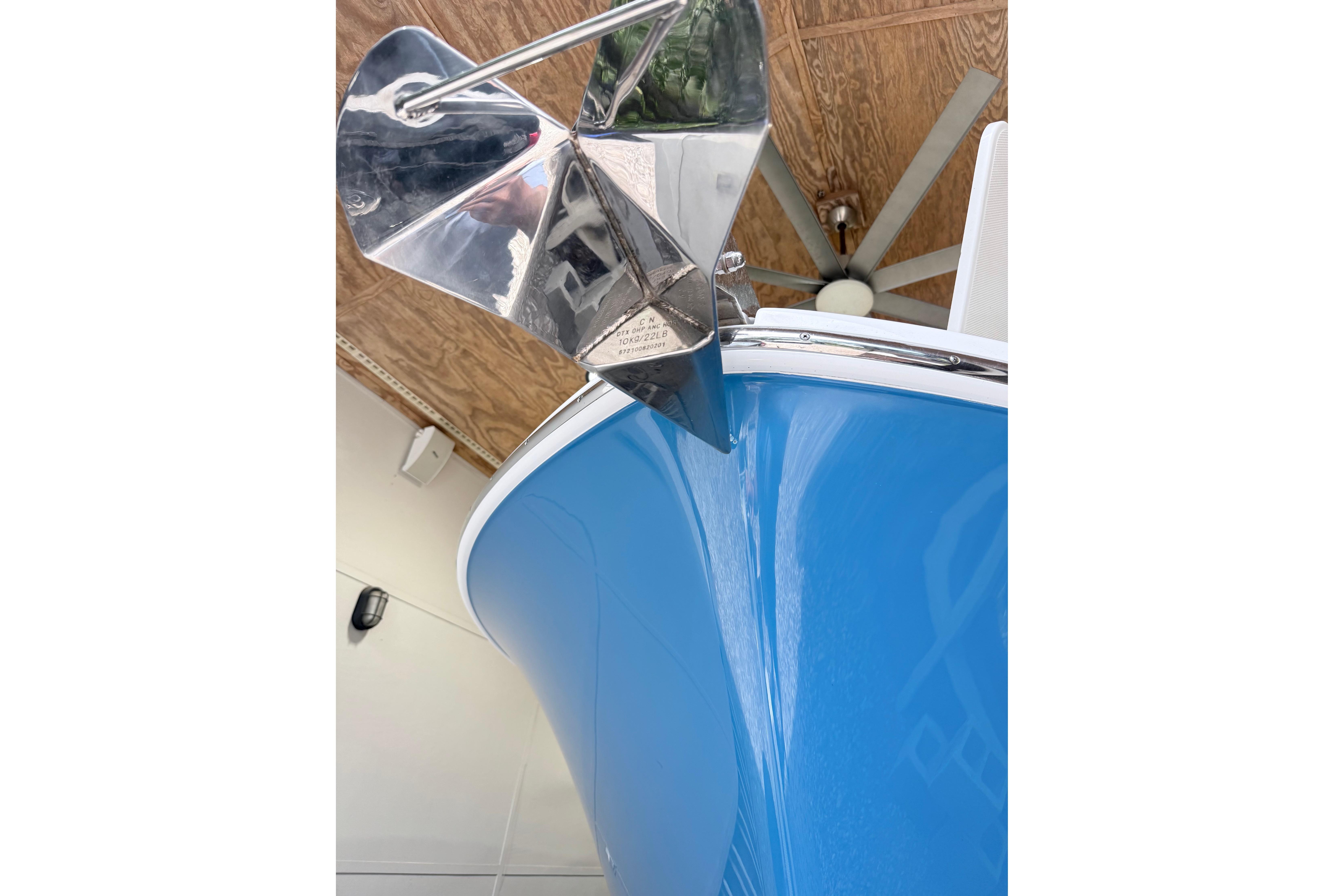 2022 Edgewater 280CC boat with a shiny anchor, displayed indoors.