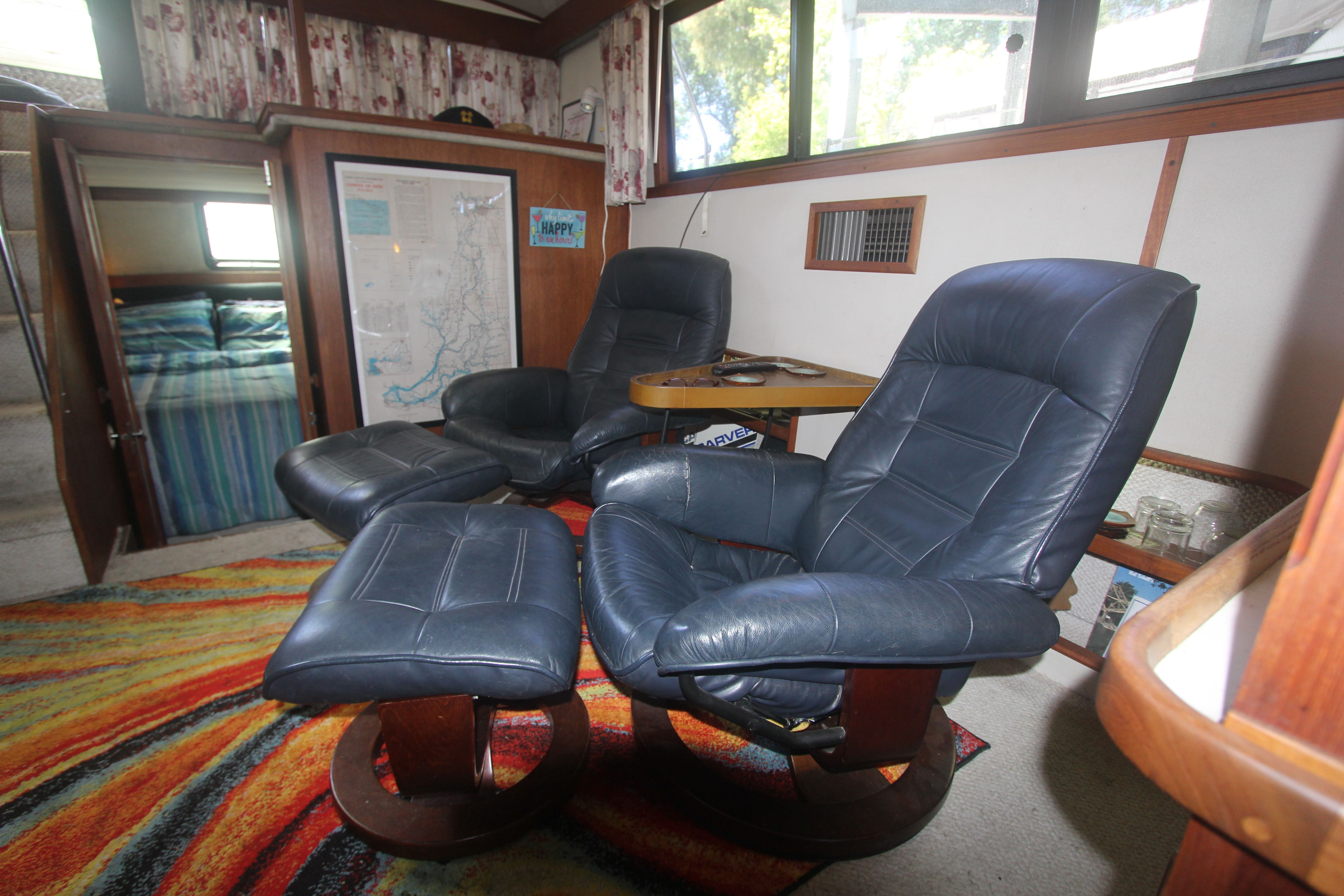 Interior of the 1988 Carver 3607 Aft Cabin Motor Yacht with blue leather chairs.