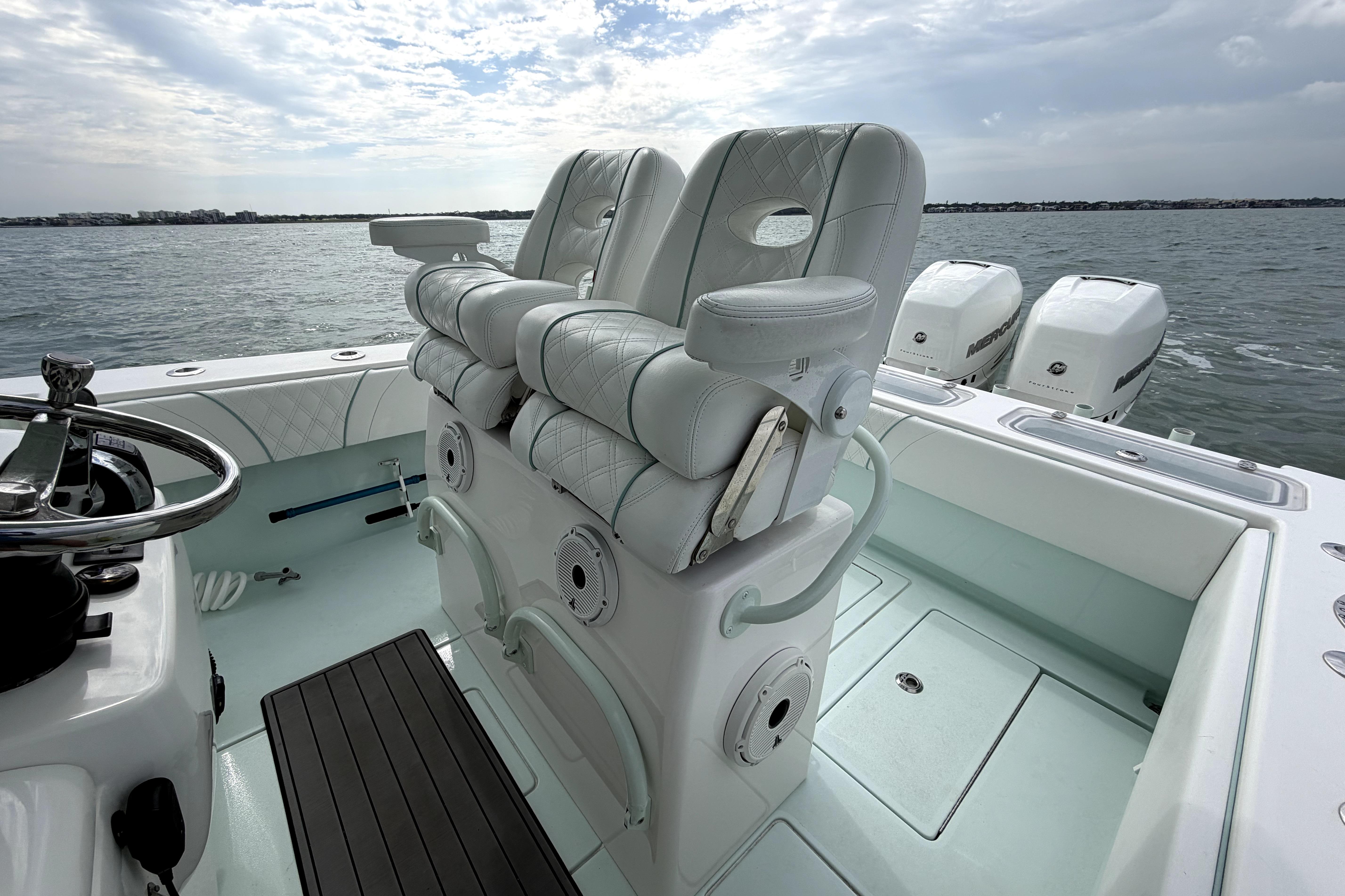2019 Contender 30 ST boat interior with dual seats and triple outboard motors on the water.