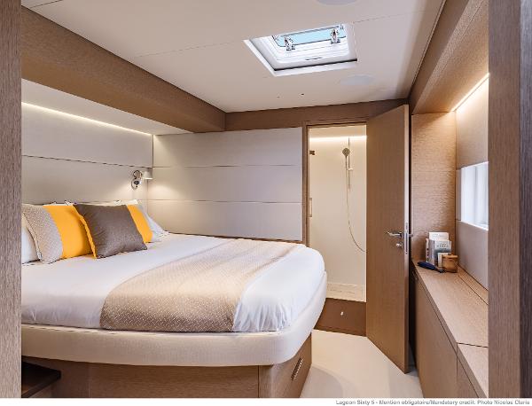 Luxurious bedroom interior of 2025 Lagoon SIXTY 5 yacht with modern design and cozy ambiance.