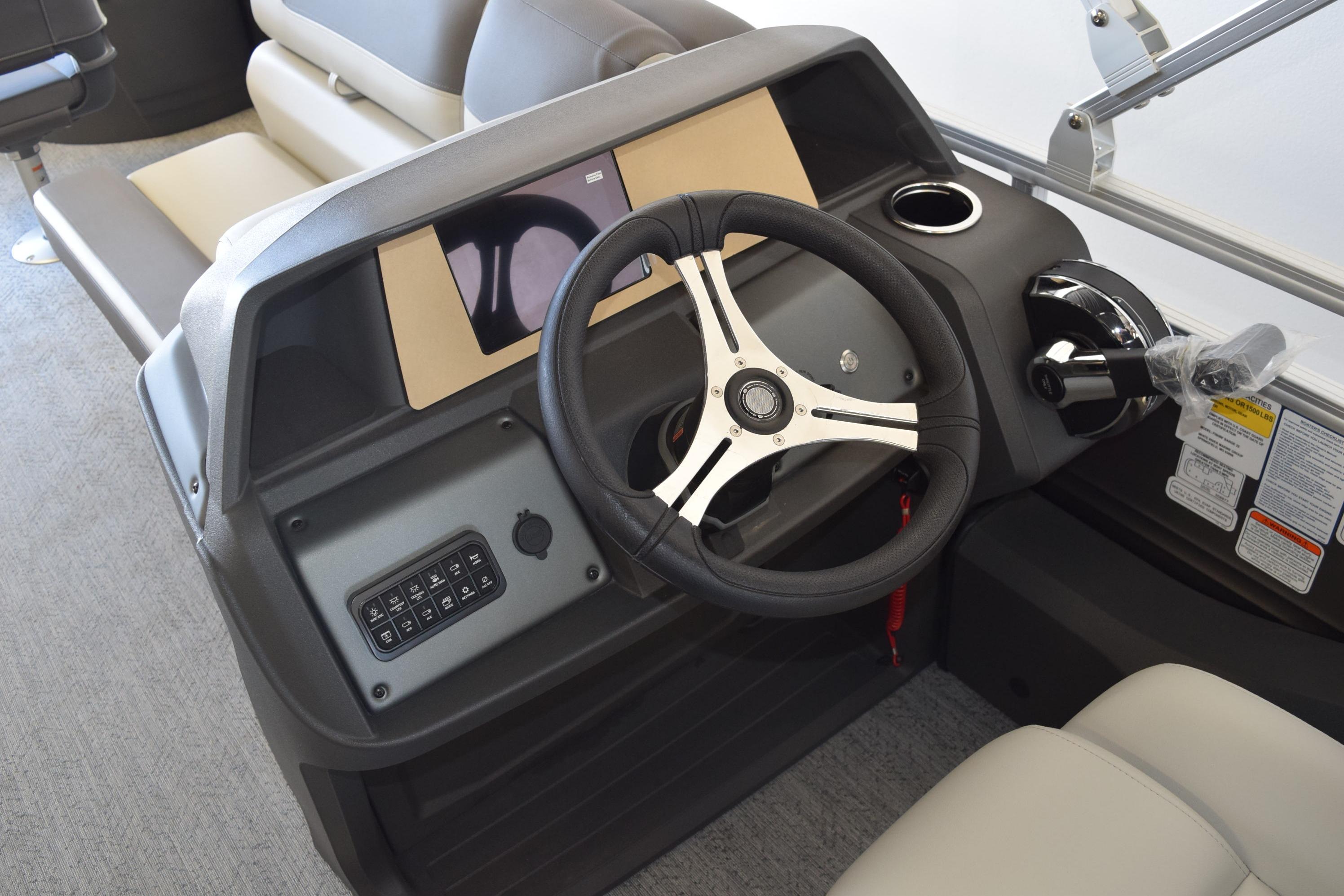 Steering console of 2026 Sun Tracker Fishin' Barge 22 DLX with modern controls and seating.