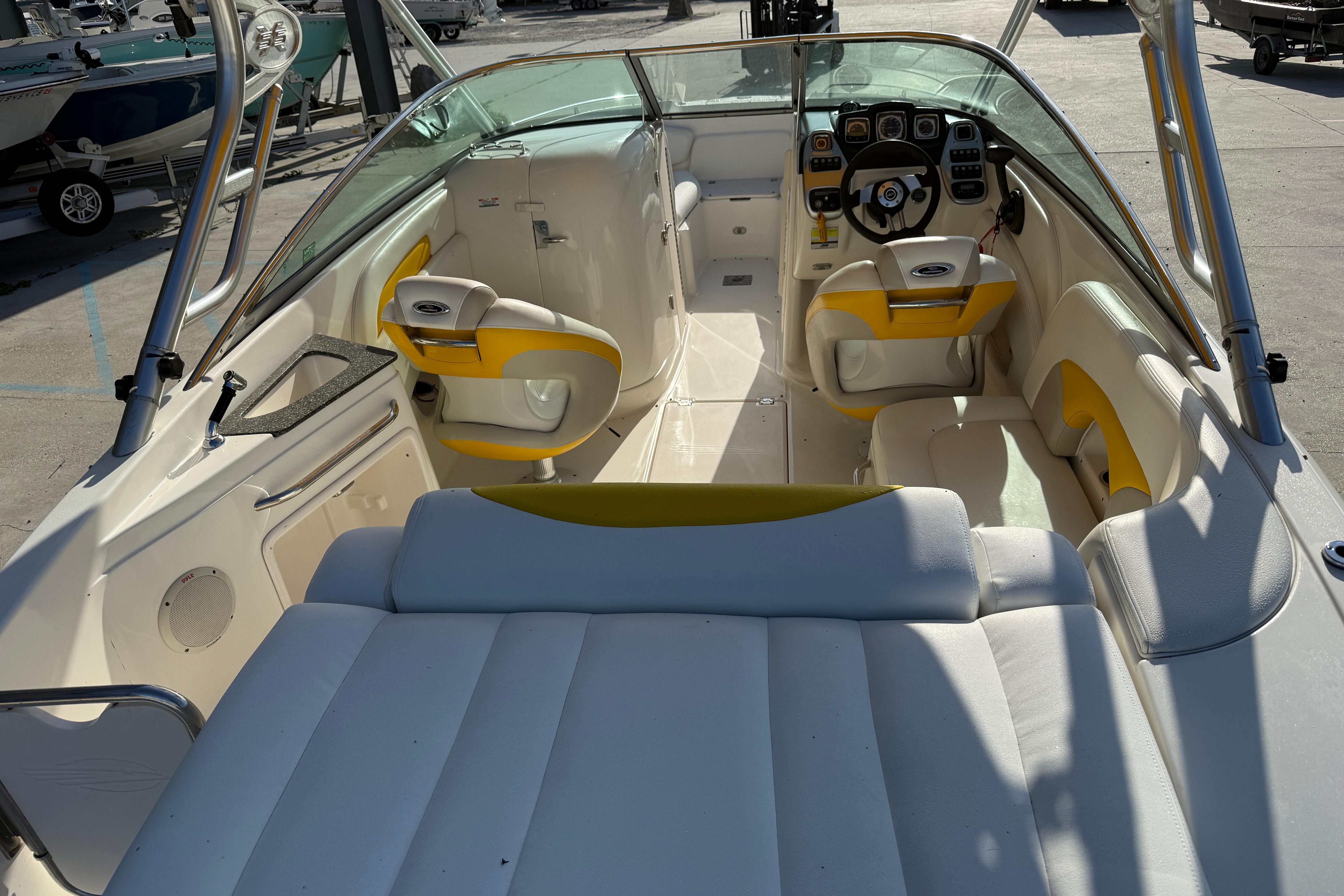 2008 Chaparral 236 SSX boat interior with yellow and white seating, steering wheel, and dashboard.