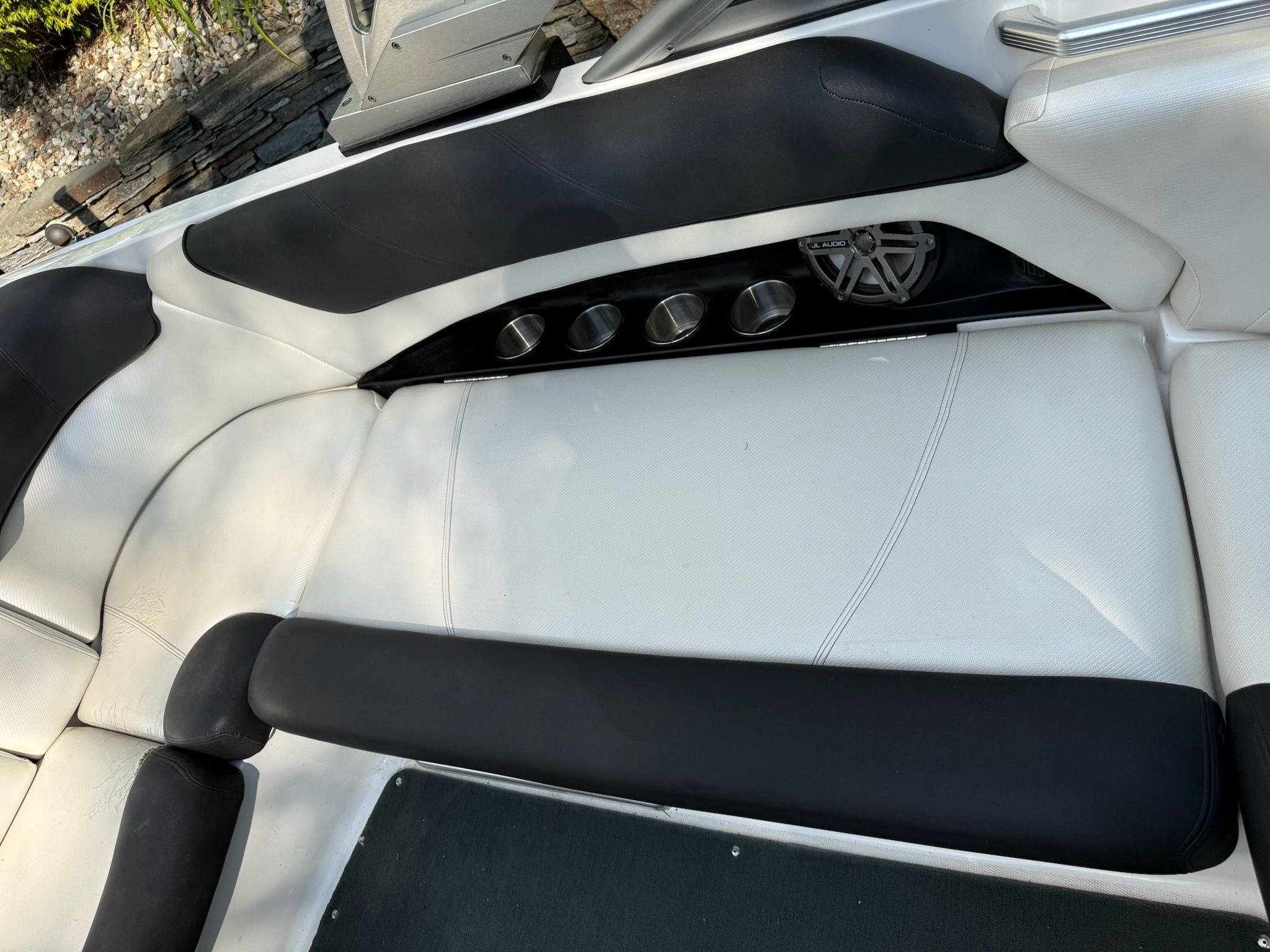 The image shows the seating area of a MasterCraft X-25 boat with white and black upholstery.