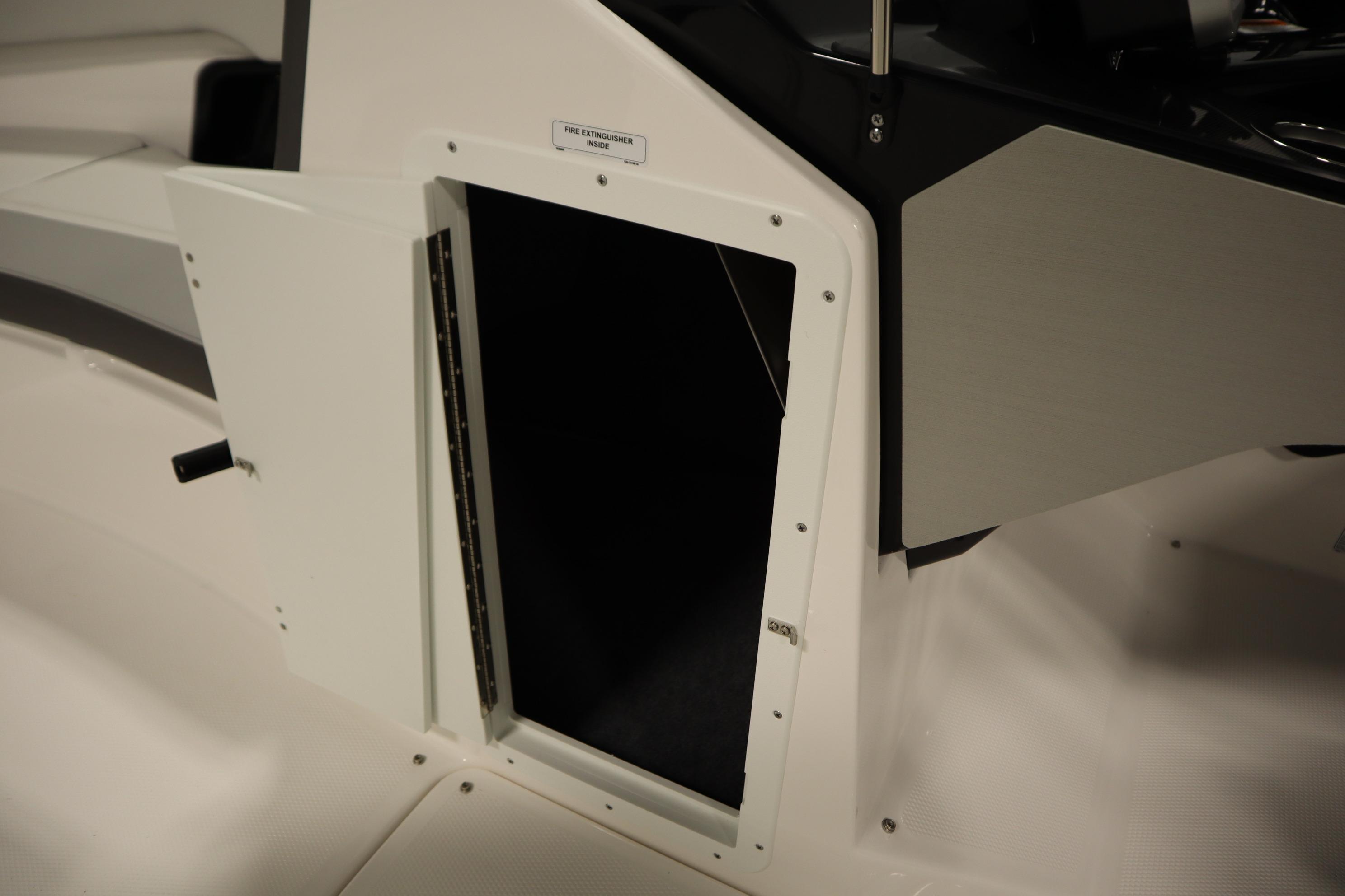 2026 Yamaha Boats AR250 storage compartment with open door, revealing interior space.