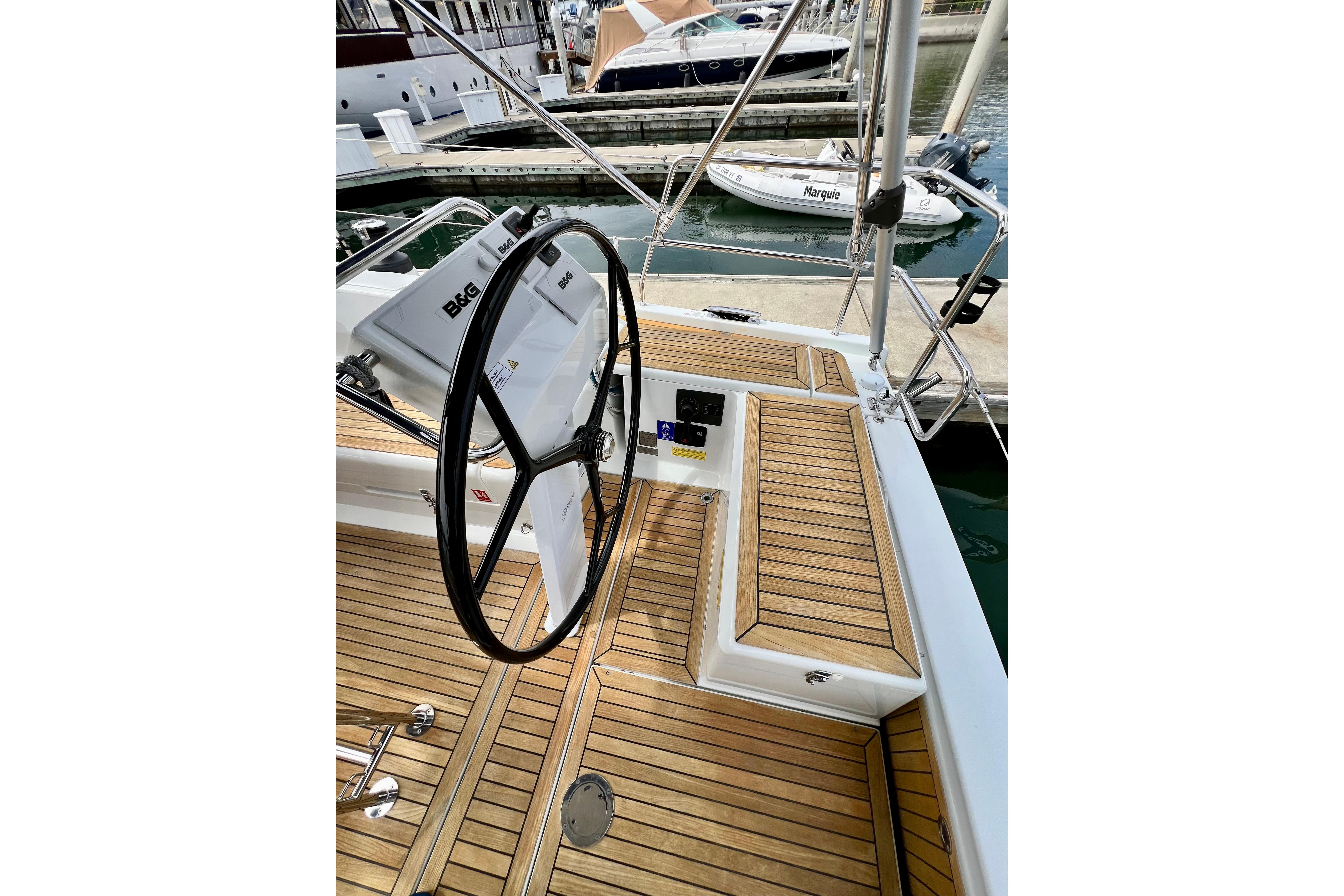 Cockpit of 2016 Hanse 455 yacht with wooden deck and steering wheel.