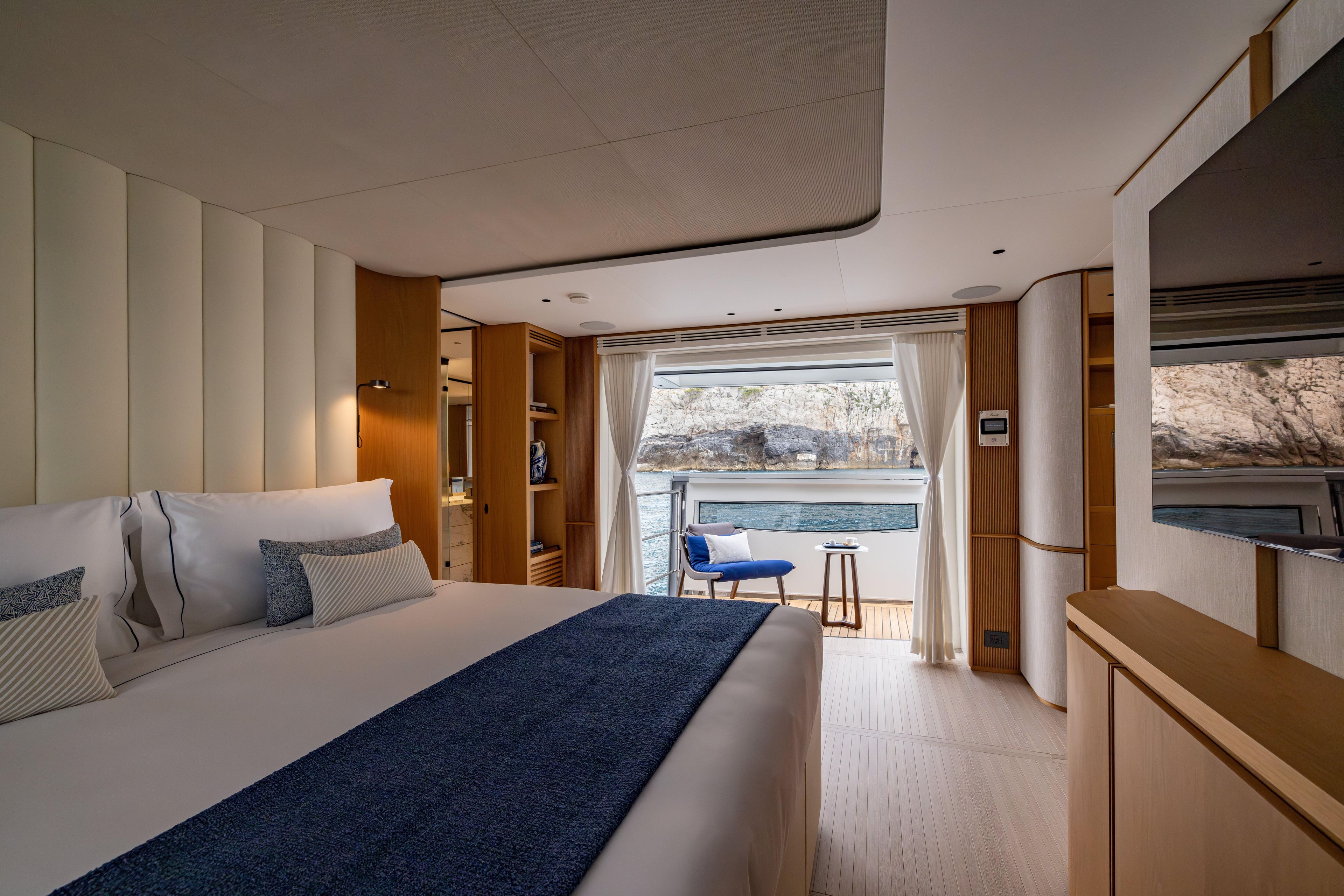 Luxurious bedroom in 2024 Benetti Oasis 34M yacht, featuring elegant decor and scenic ocean view.
