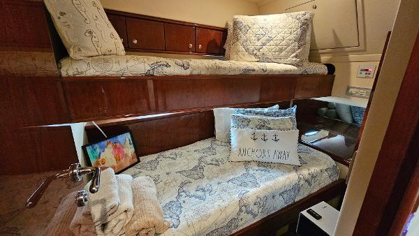 Cozy cabin interior of 2005 Neptunus 56 Flybridge with nautical-themed bedding.