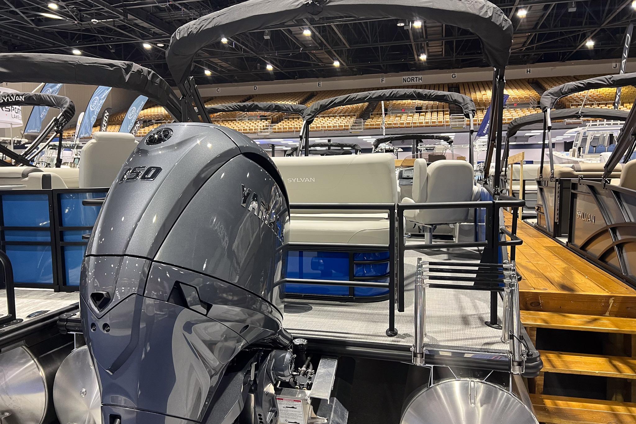 2026 Sylvan Mirage 822 CLZ pontoon boat with Yamaha outboard motor at indoor exhibition.