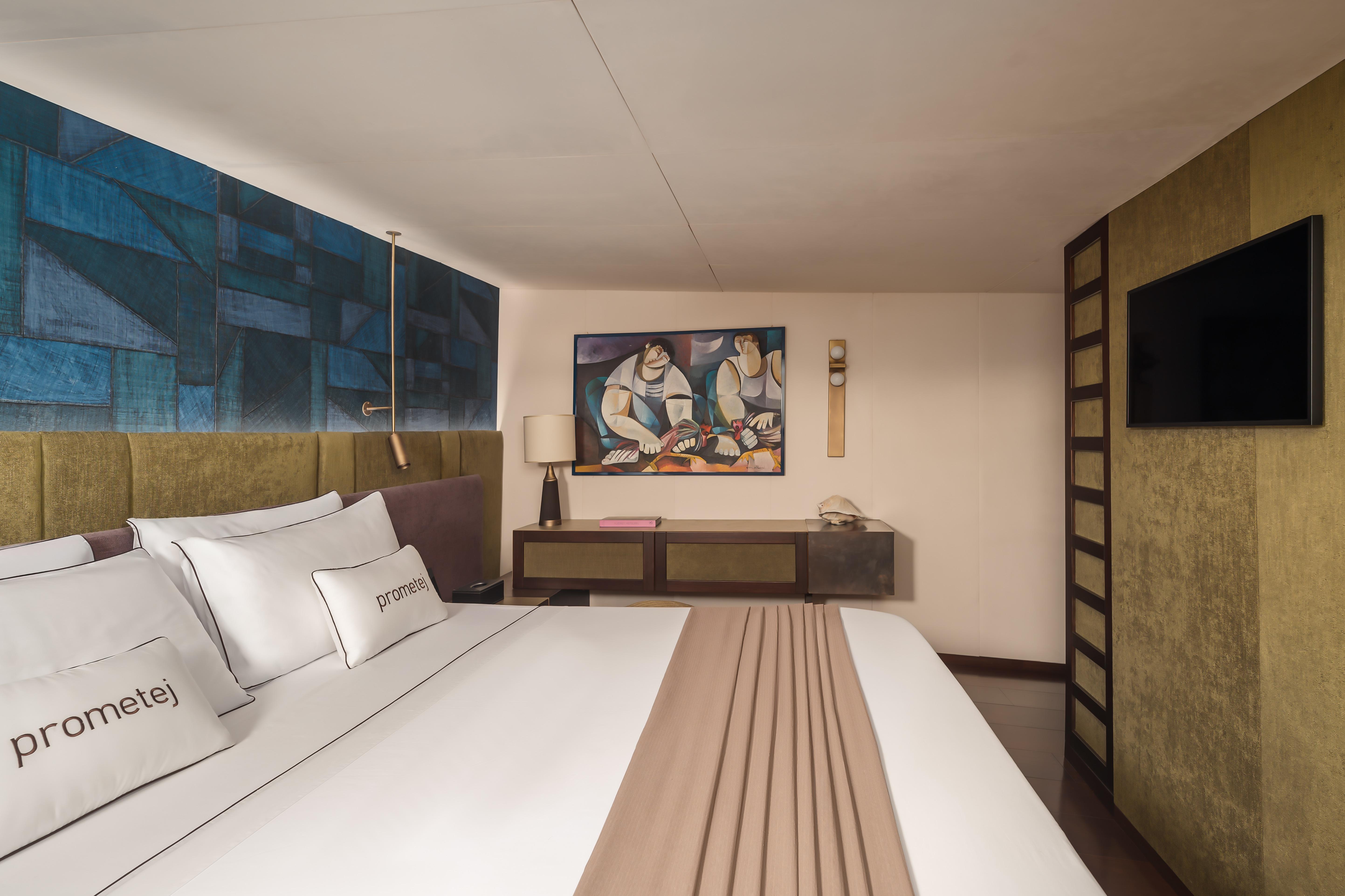 Luxurious bedroom in a converted 1956 tugboat, featuring modern decor and artwork.