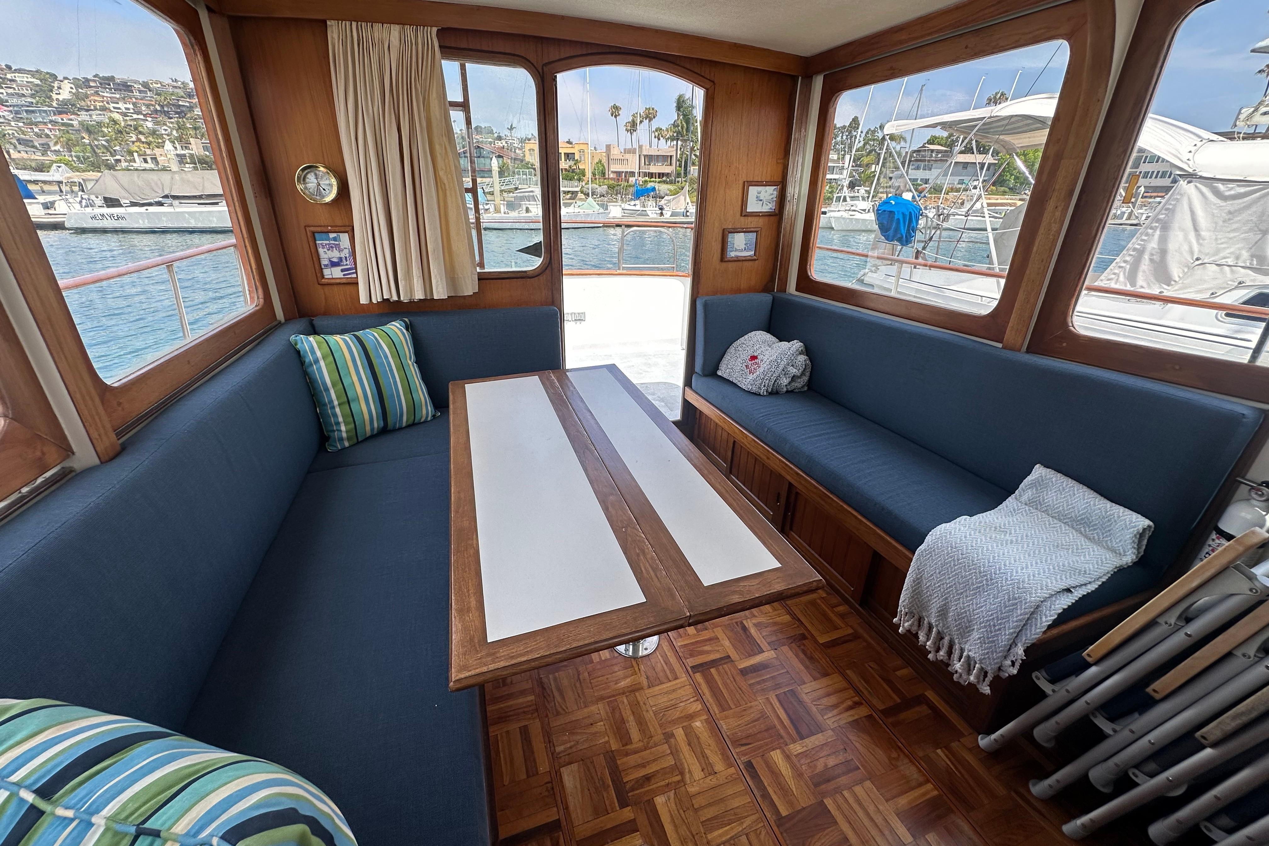 Interior of a 1973 CHB 33 boat with blue seating and wooden table.