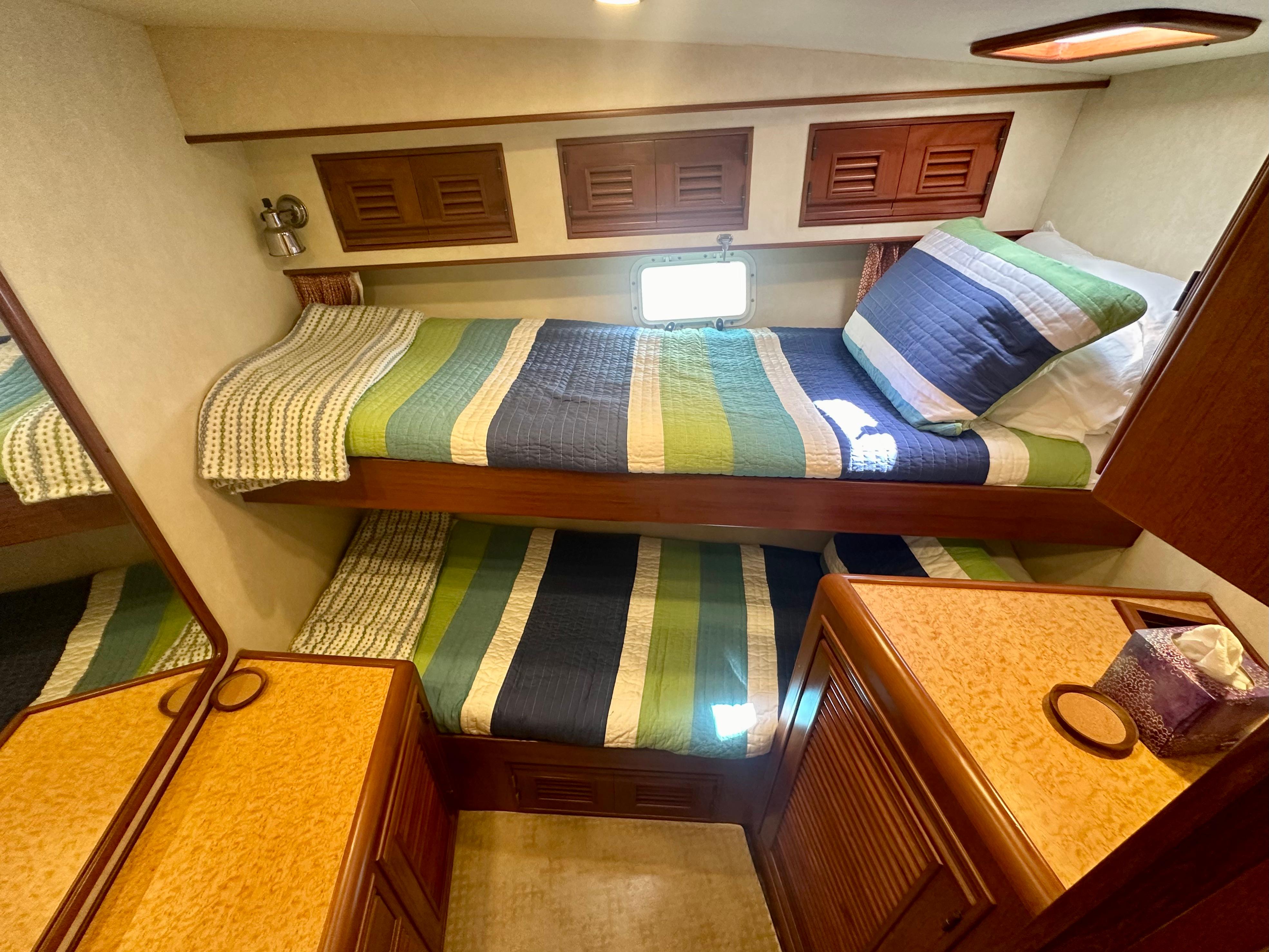 2000 Offshore Yachts Pilothouse cabin with bunk beds and colorful bedding.