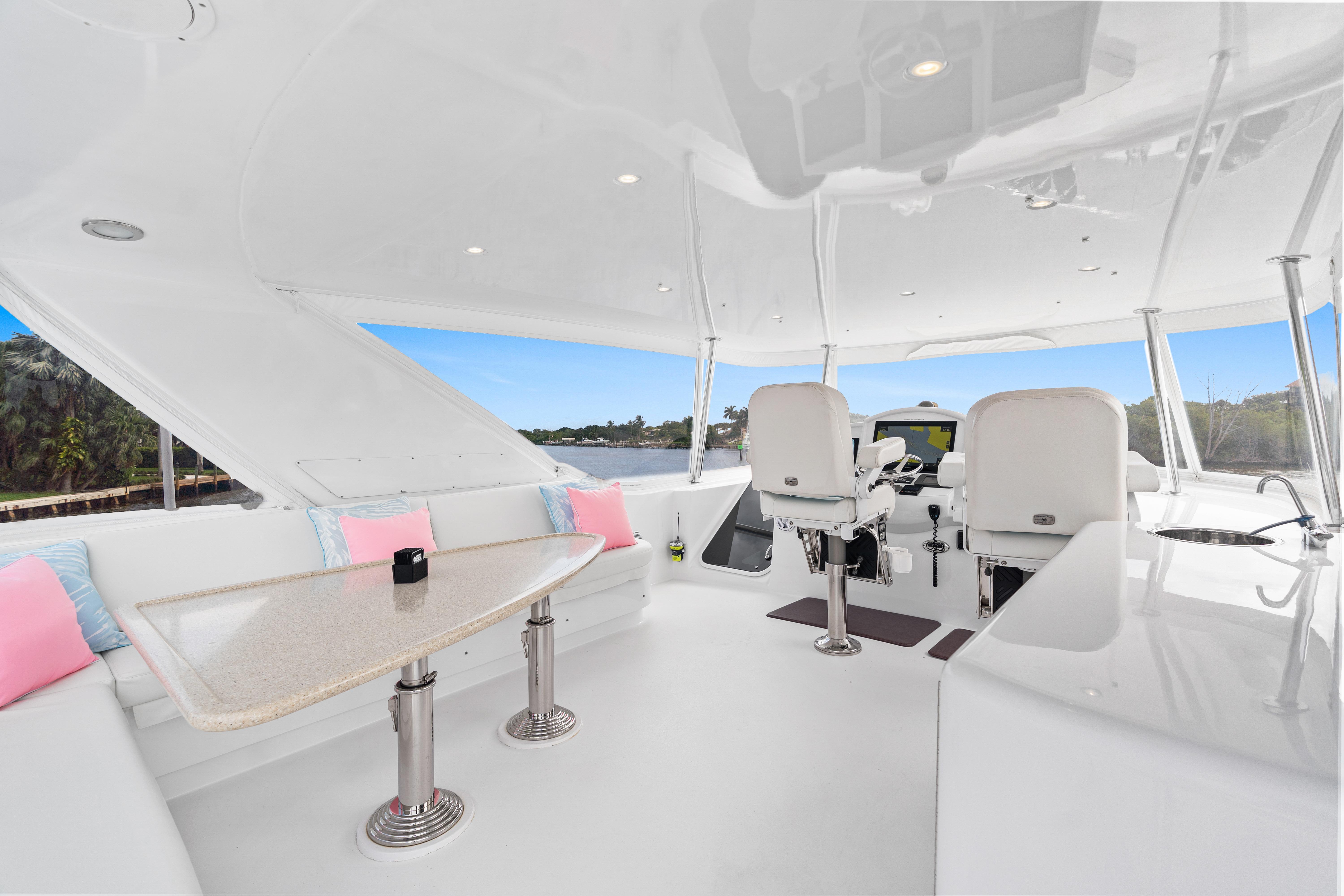 Luxurious interior of 2008 Hatteras 64 Motor Yacht with helm and seating area.