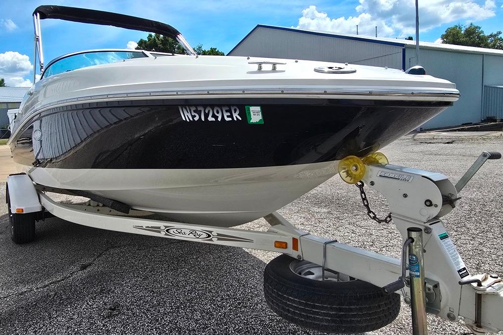 2006 Sea Ray 185 Sport boat on trailer, parked outdoors under a clear sky.