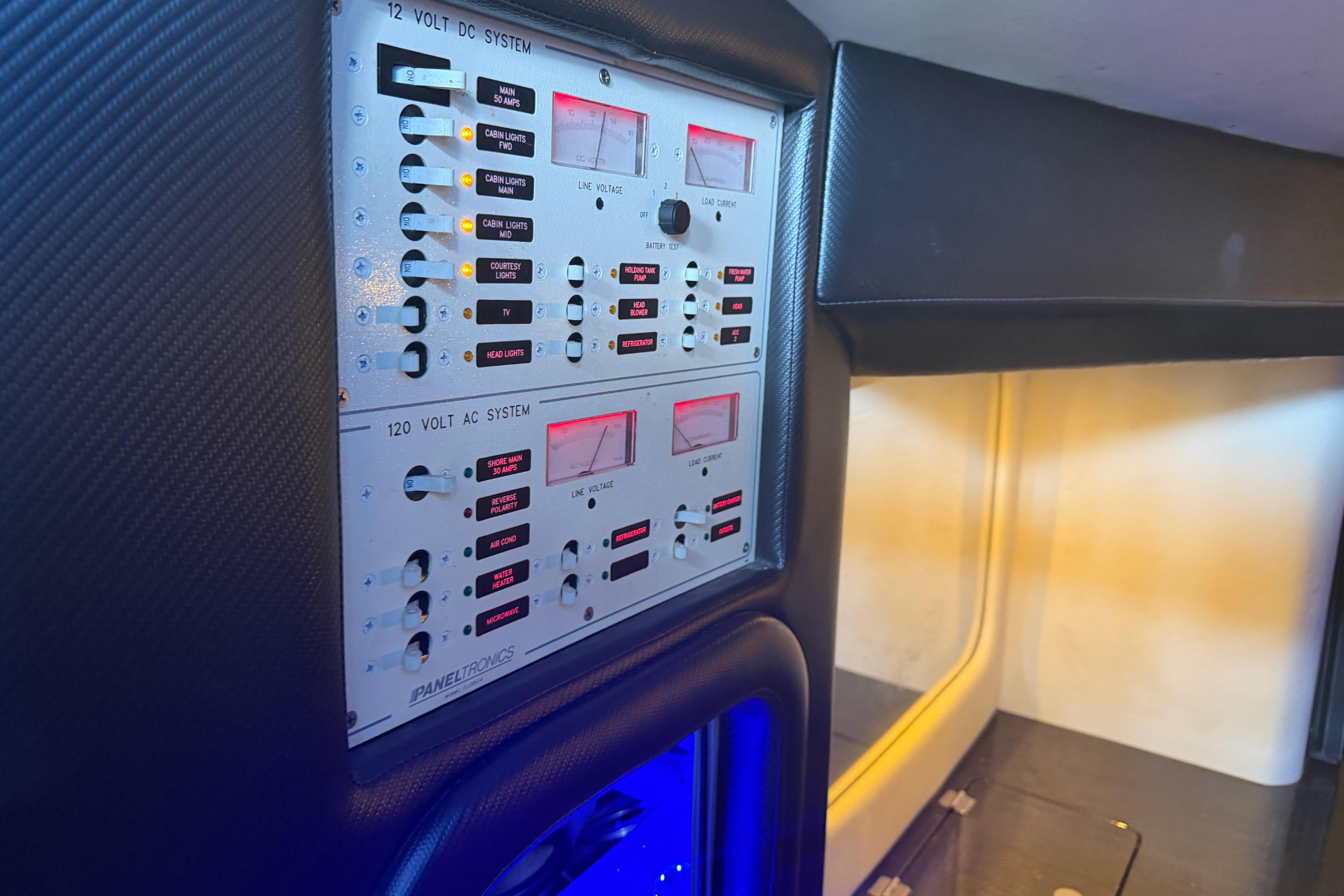 Control panel inside 2013 Nor-Tech 477 SPX Vee Bottom boat, featuring AC and DC systems.
