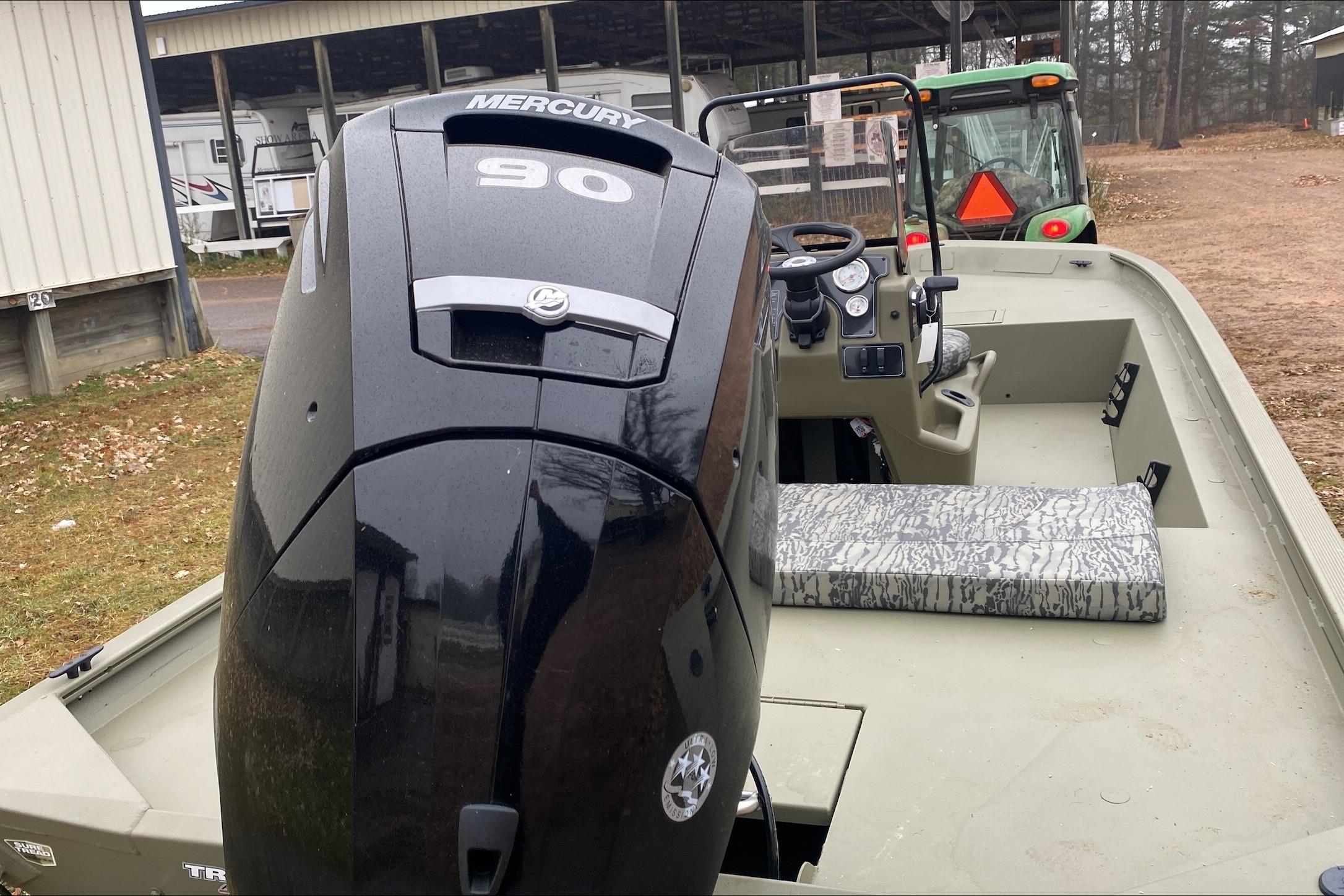 2026 Tracker Grizzly 1860 CC boat with Mercury 90 engine, parked outdoors.
