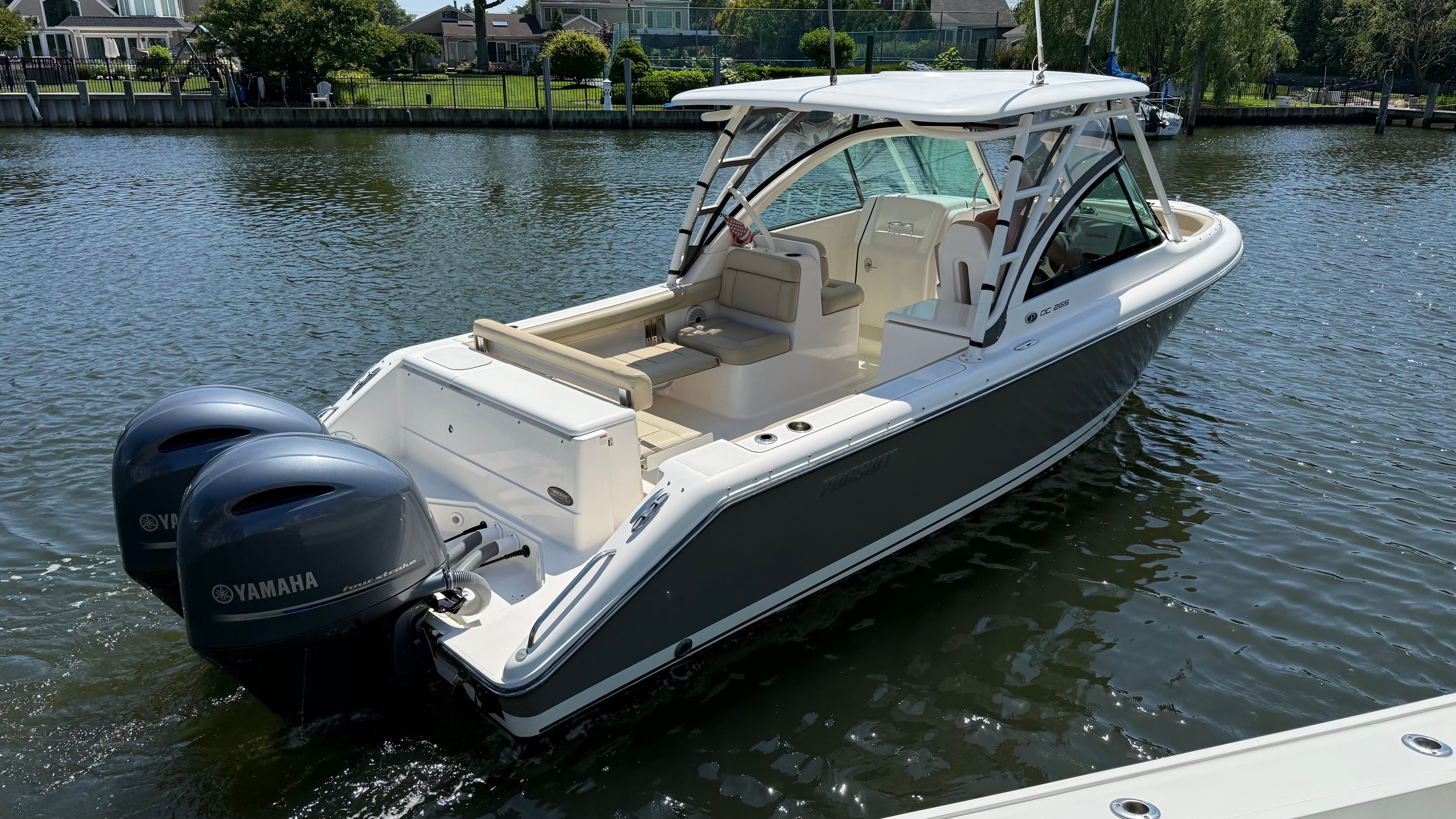 A 2016 Pursuit DC 265 Dual Console boat on calm water.
