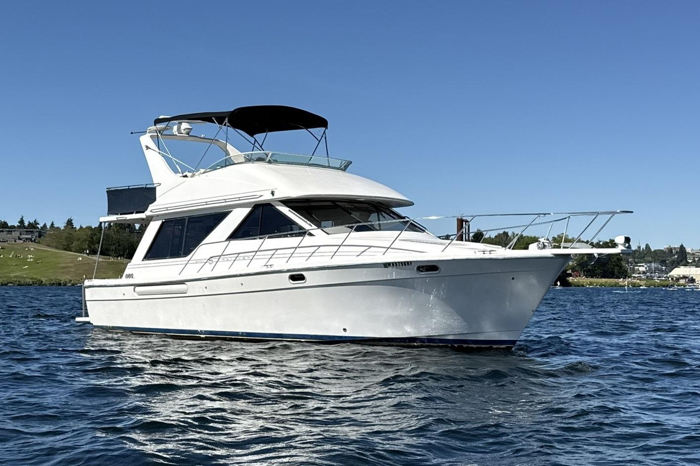1997 Bayliner 3988 Command Bridge Motoryacht on calm water under clear blue sky.