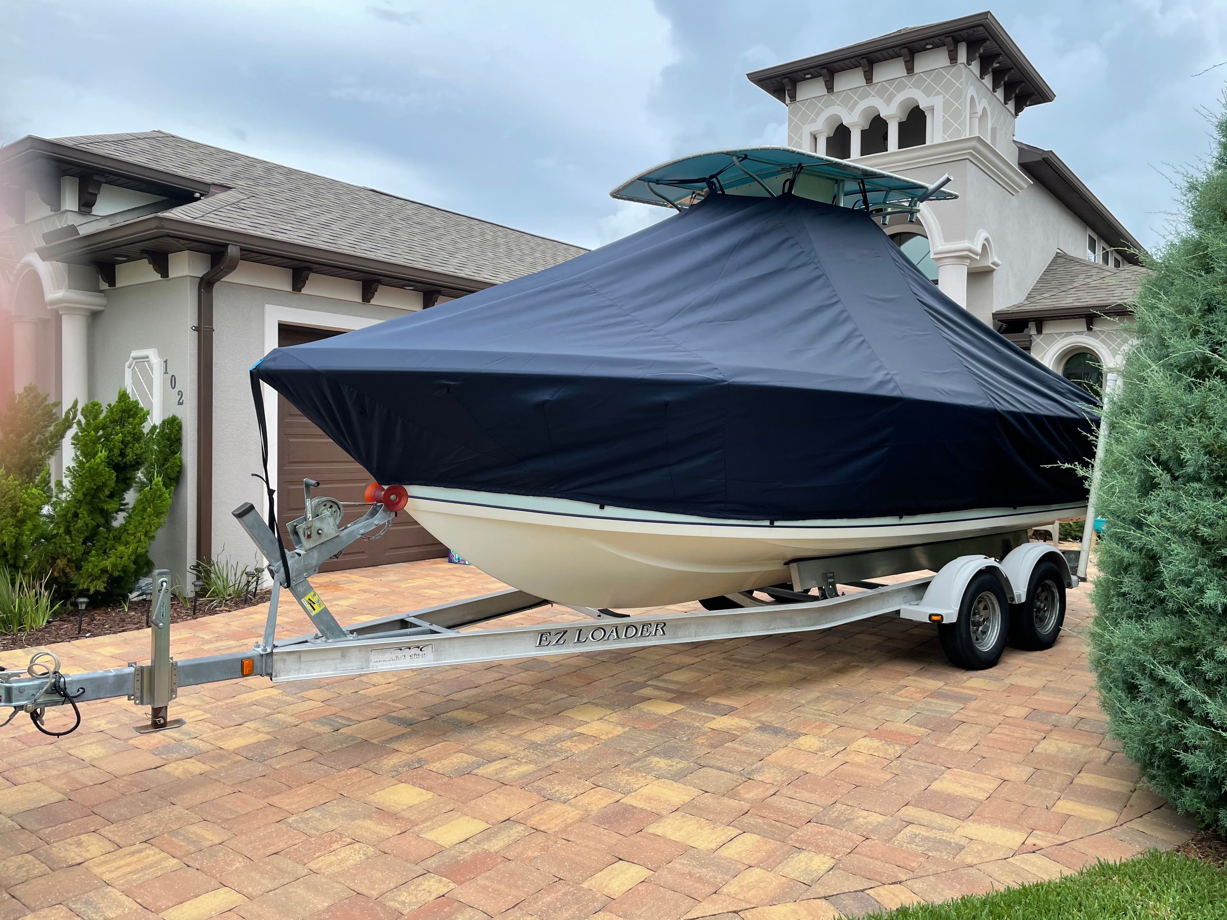 2006 Sailfish 218 CC boat on trailer in front of house.