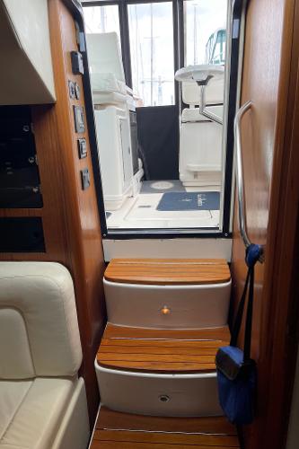 Interior of the 2003 Tiara Yachts 3500 Open with wooden steps and white seating.